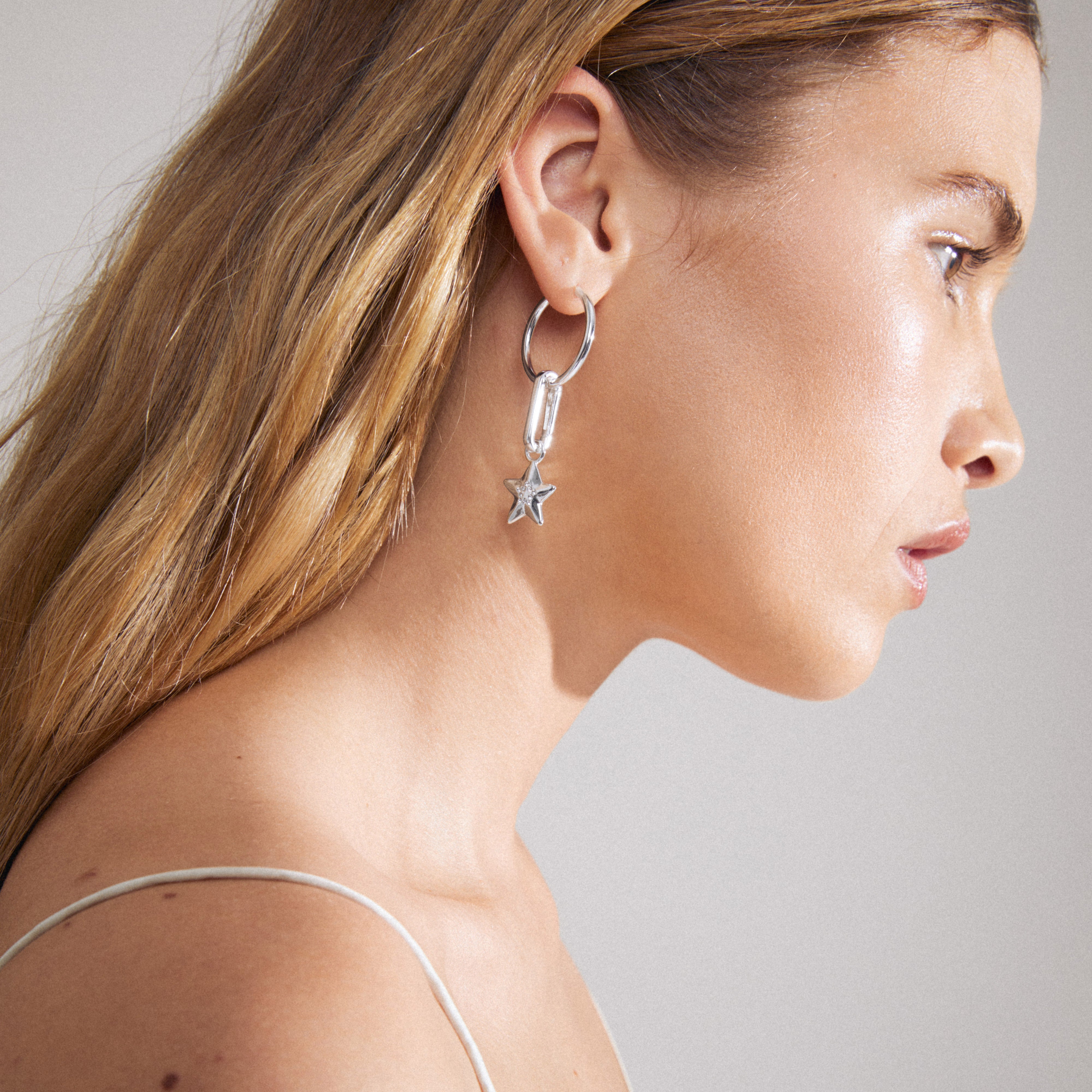 CHARM large hoop earrings silver-plated, worn by a woman, showcasing their versatile design for adding personal charms. Perfect for everyday wear and personalizing your style.