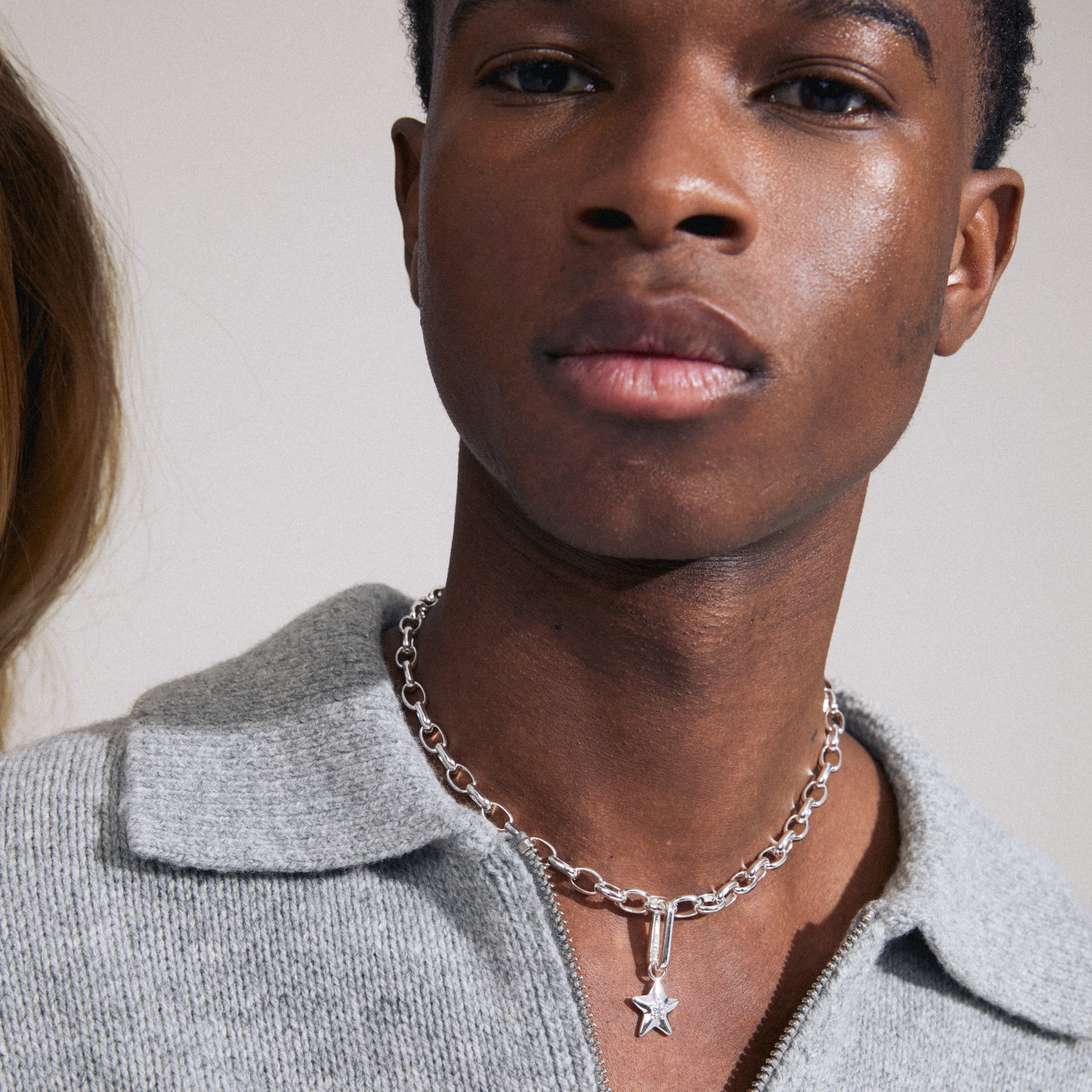 Man wearing a silver-plated CHARM star pendant by Pilgrim, featuring a star design with Preciosa crystals, highlighting its unique, personalized style.