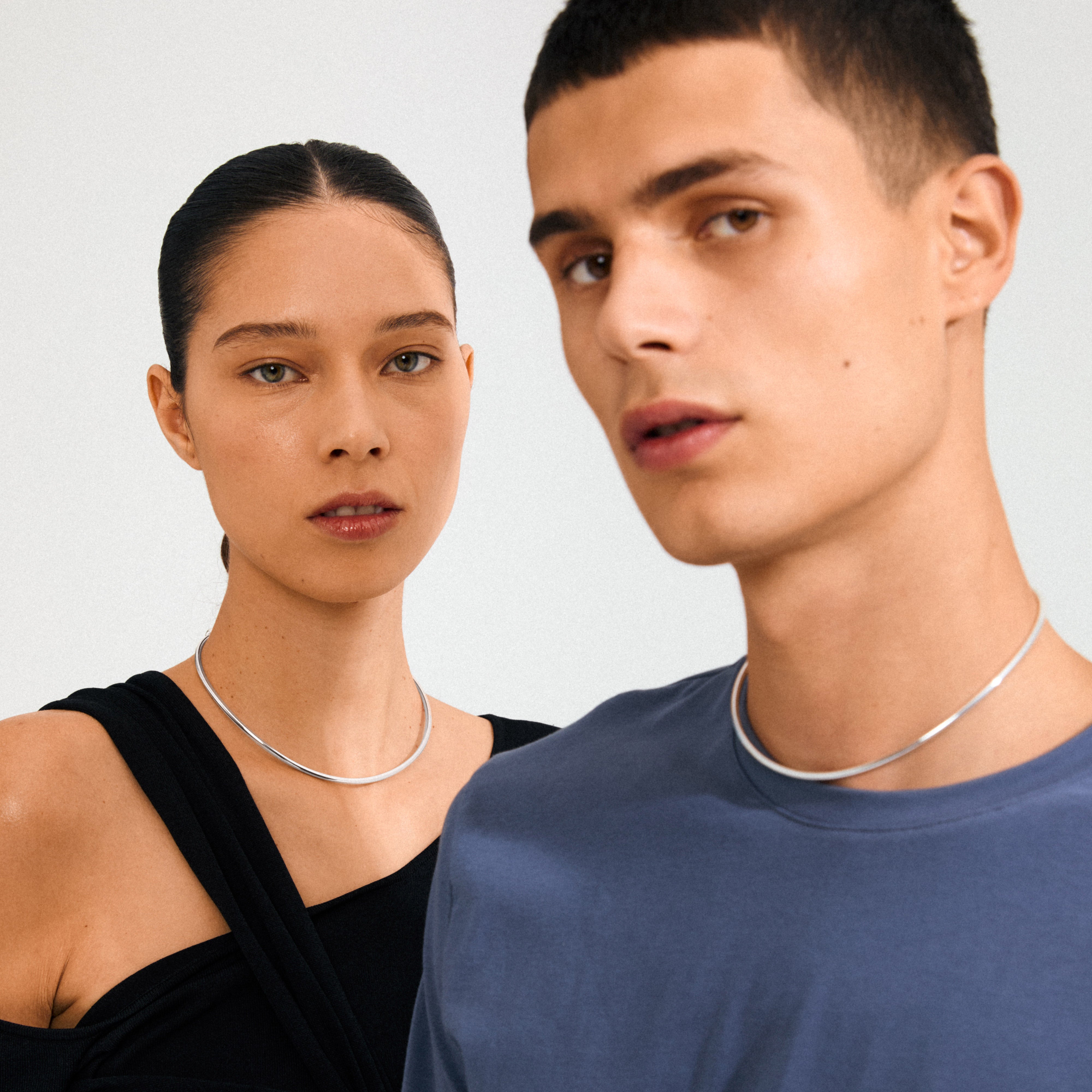 Two young adults wear the CHARM choker silver-plated necklaces, showcasing a minimalist design perfect for personalization with charms.
