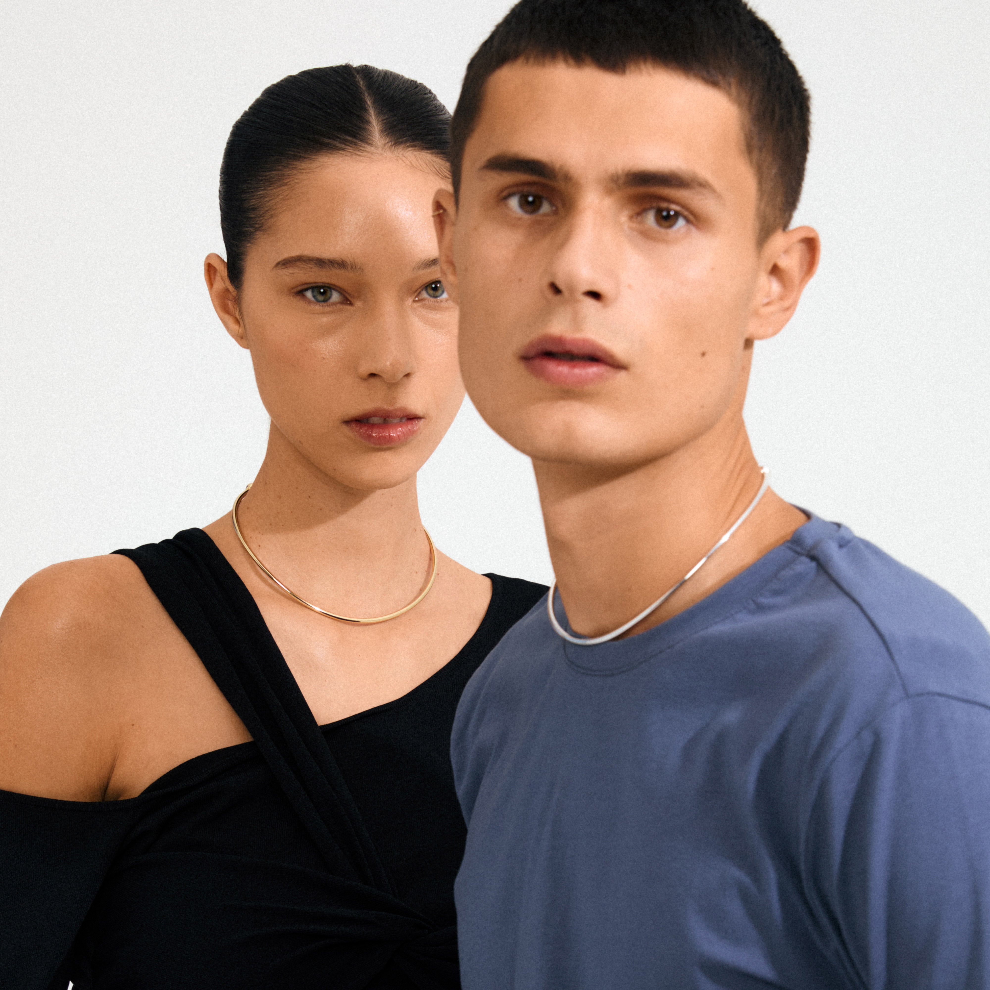 Two young adults model Pilgrim's CHARM choker silver-plated, highlighting its elegant, timeless design with decorative ball clasps for adding charms.