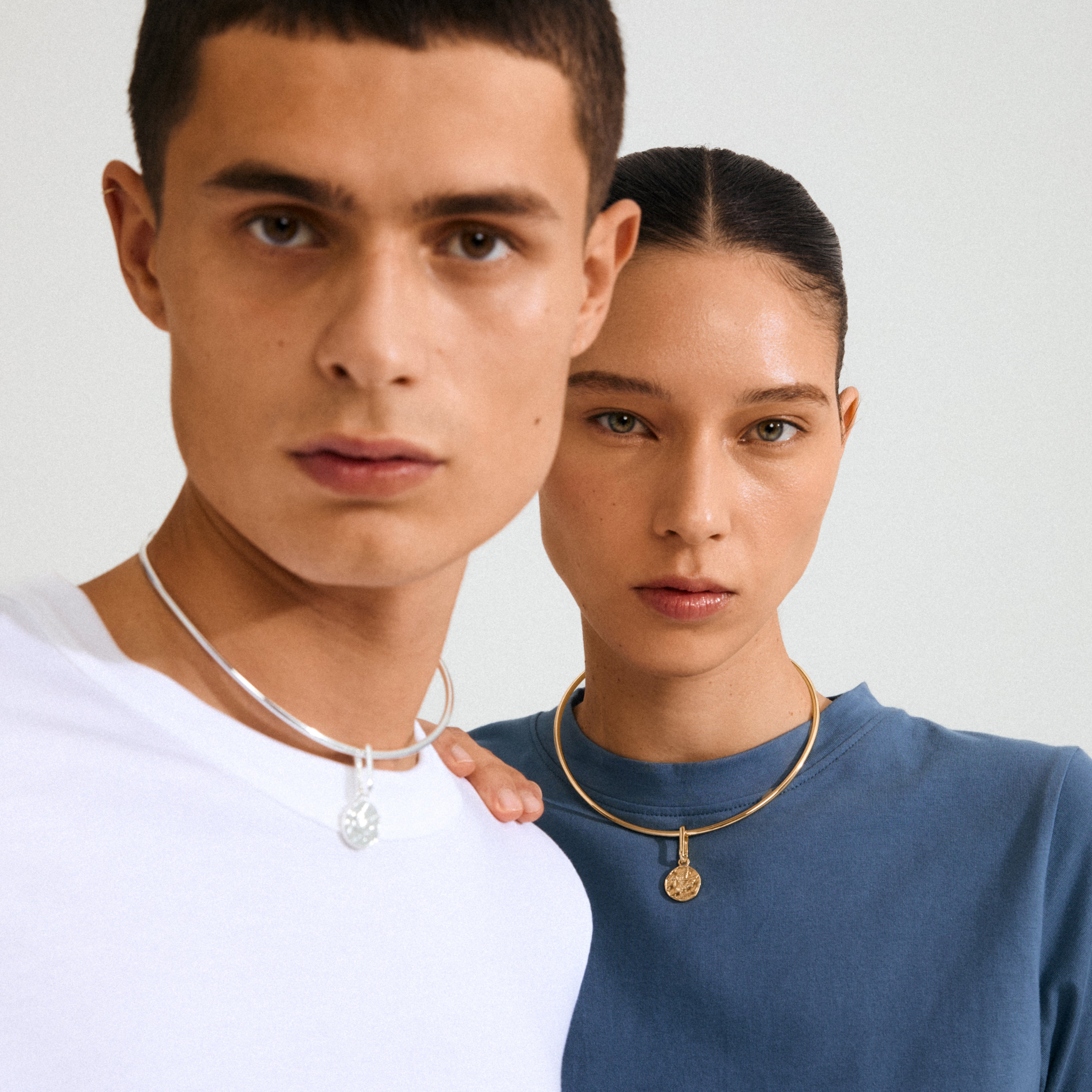 Two models showcase Pilgrim's CHARM peace dove pendant, silver-plated, emphasizing its serene symbolism and rustic design, perfect for a personalized, meaningful style.