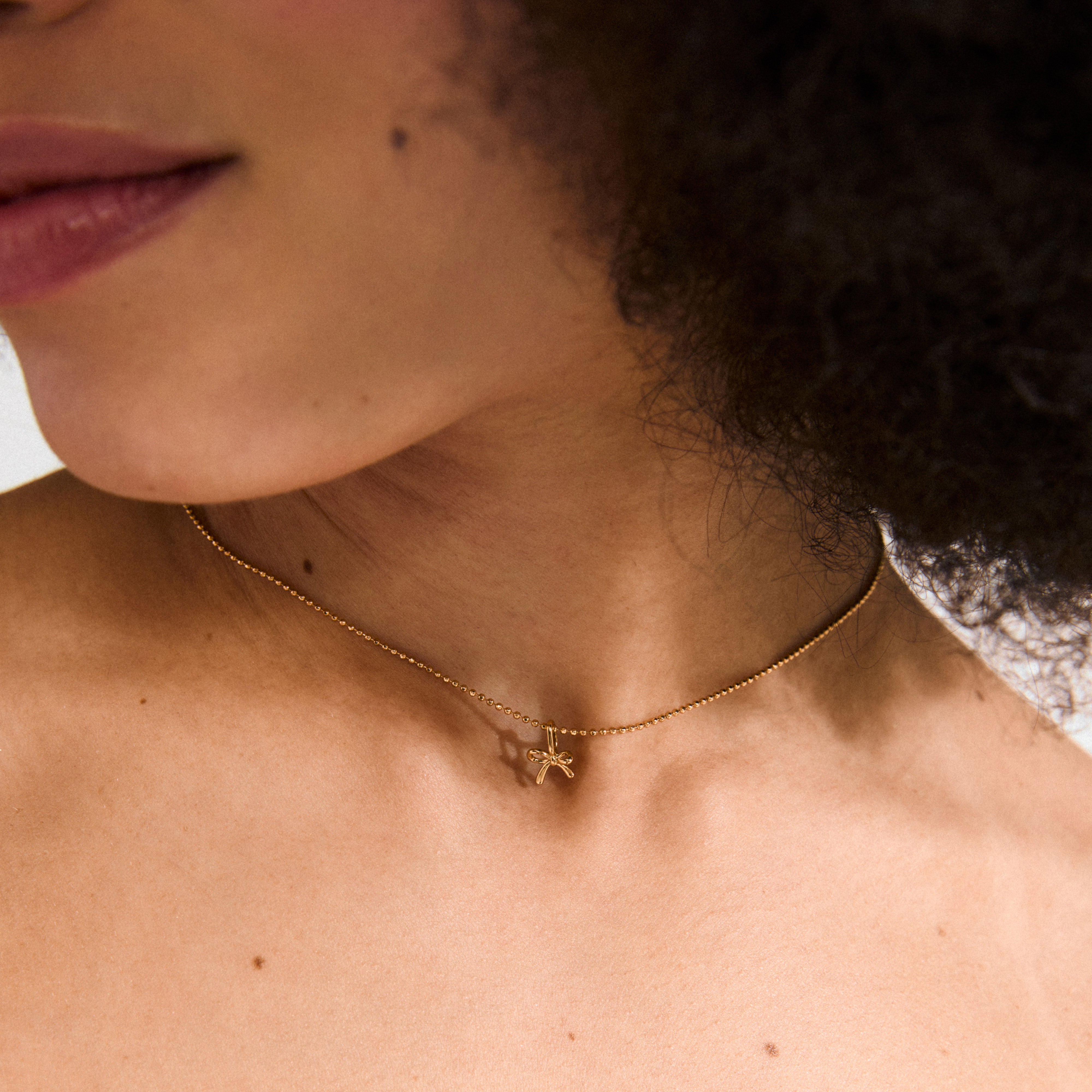 Gold-plated CHARM mini bow pendant, perfect for earrings, necklaces, or bracelets. Water-resistant and eco-friendly, made from 99% recycled materials. Ideal for a stylish, personalized look.