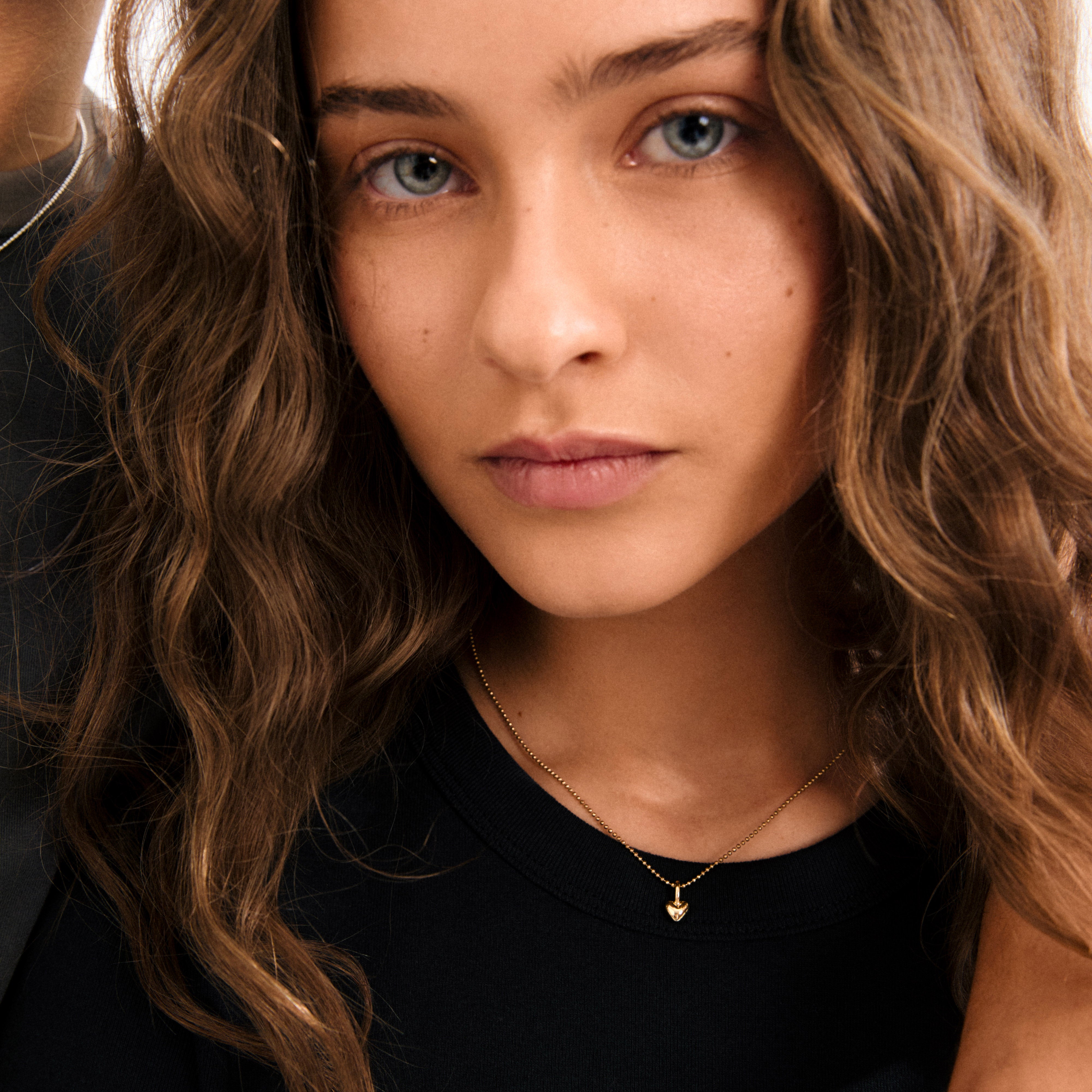 Gold-plated mini heart pendant from Pilgrim, perfect for personal expression. Versatile for hoops, chains, or bracelets, combining minimalist design with sustainable, recycled materials.