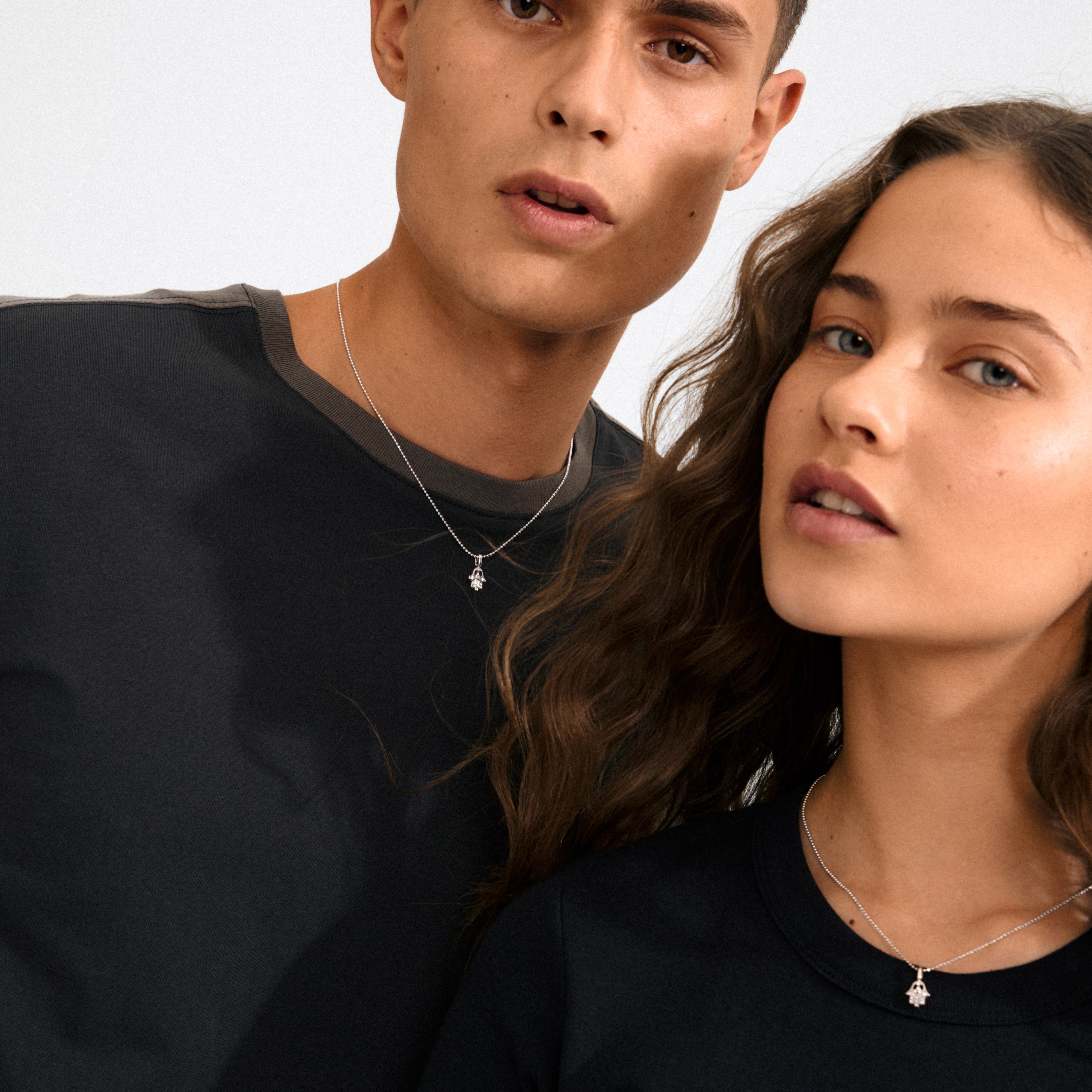 Silver-plated CHARM mini Hamsa pendant with sparkling crystals, embodying mystique and spirituality. Crafted from 98% recycled materials for personal, layered styling.