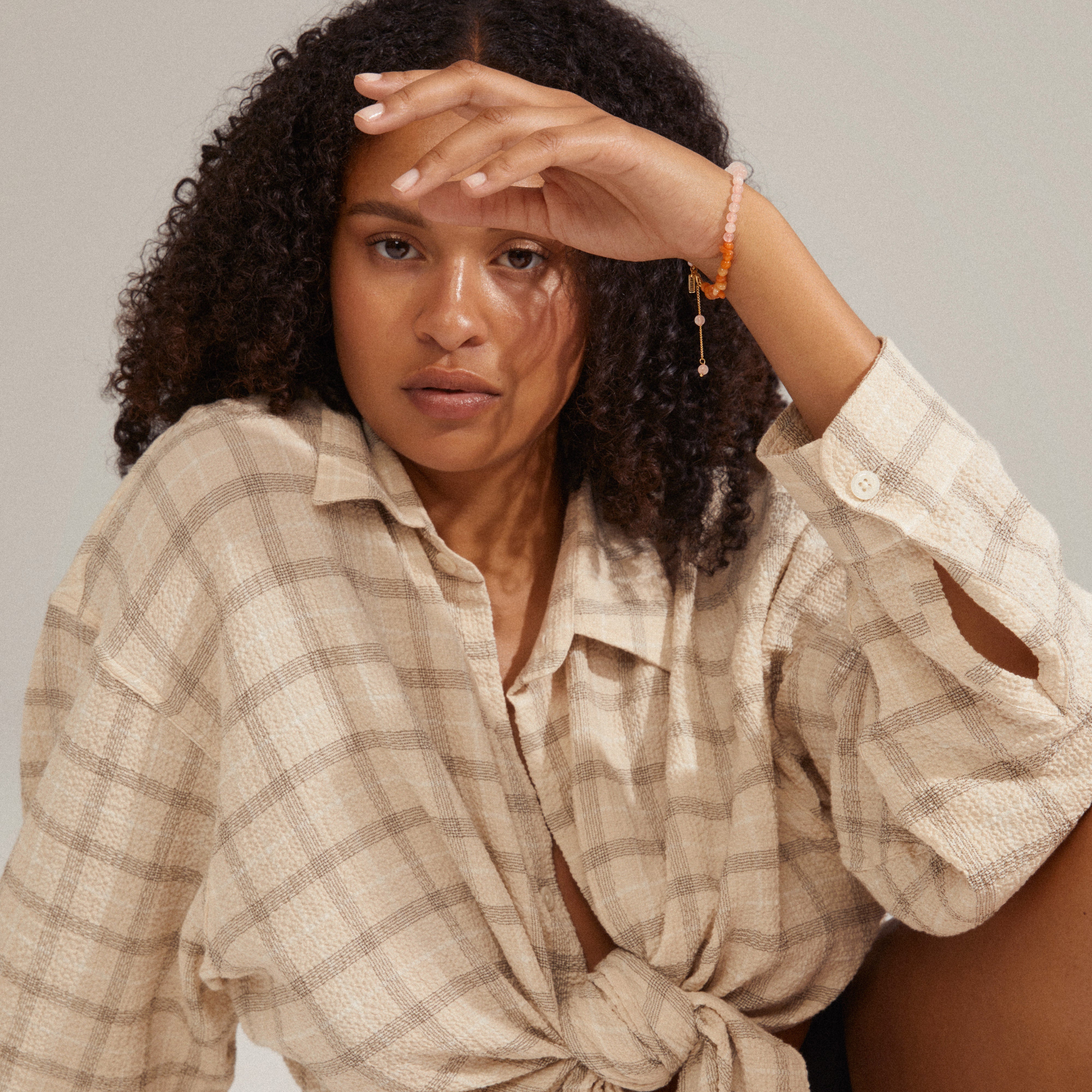Woman wearing the SOULMATES bracelet rose/gold-plated, showcasing asymmetrical beads in delicate shades, adding a touch of elegance to her style.