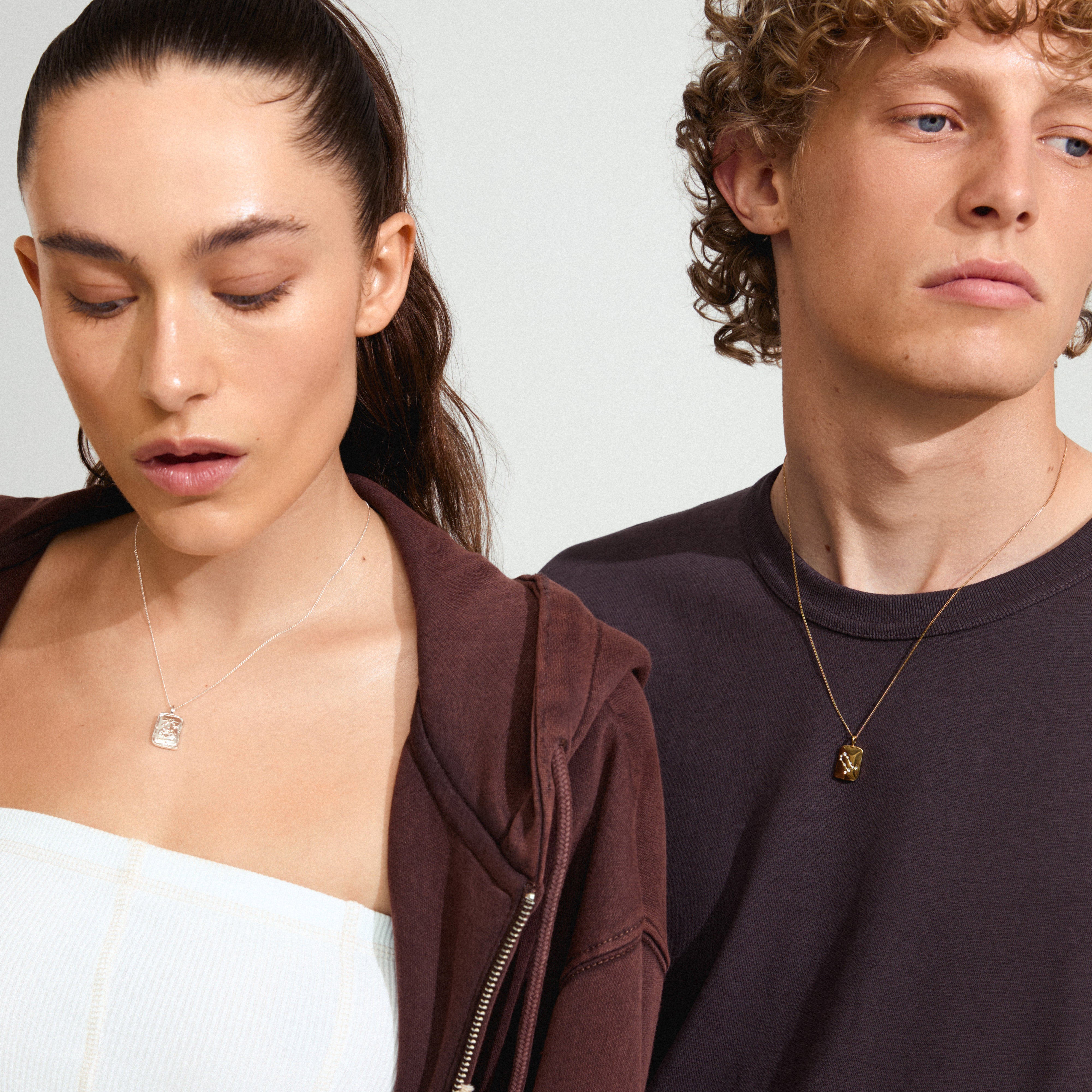 A man wears the GEMINI Zodiac Sign necklace, silver-plated, featuring a dual-design square coin pendant with a rustic, handcrafted look.