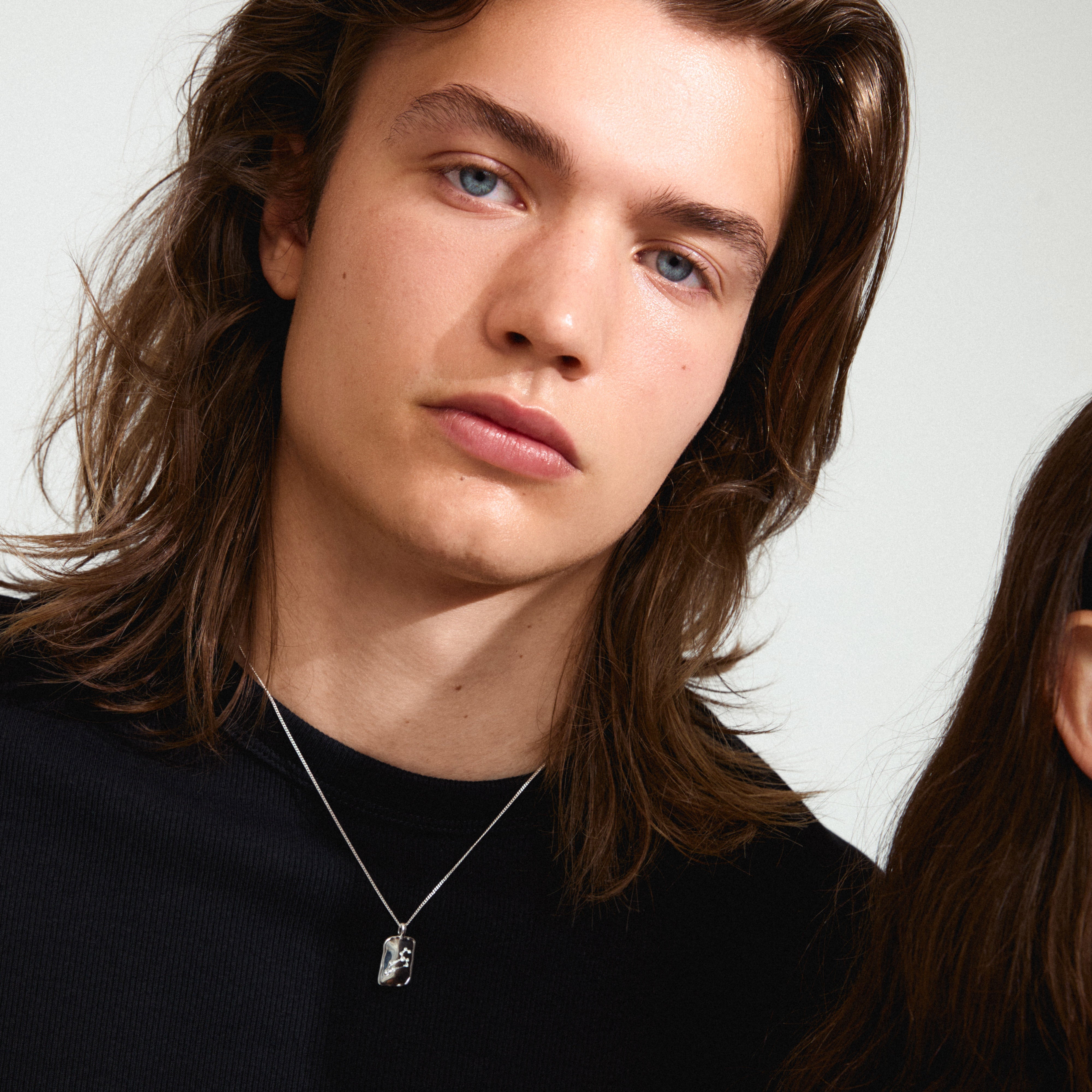 Close-up of a person wearing the LEO Zodiac Sign necklace, silver-plated, featuring a dual design pendant with a rustic, handcrafted look.