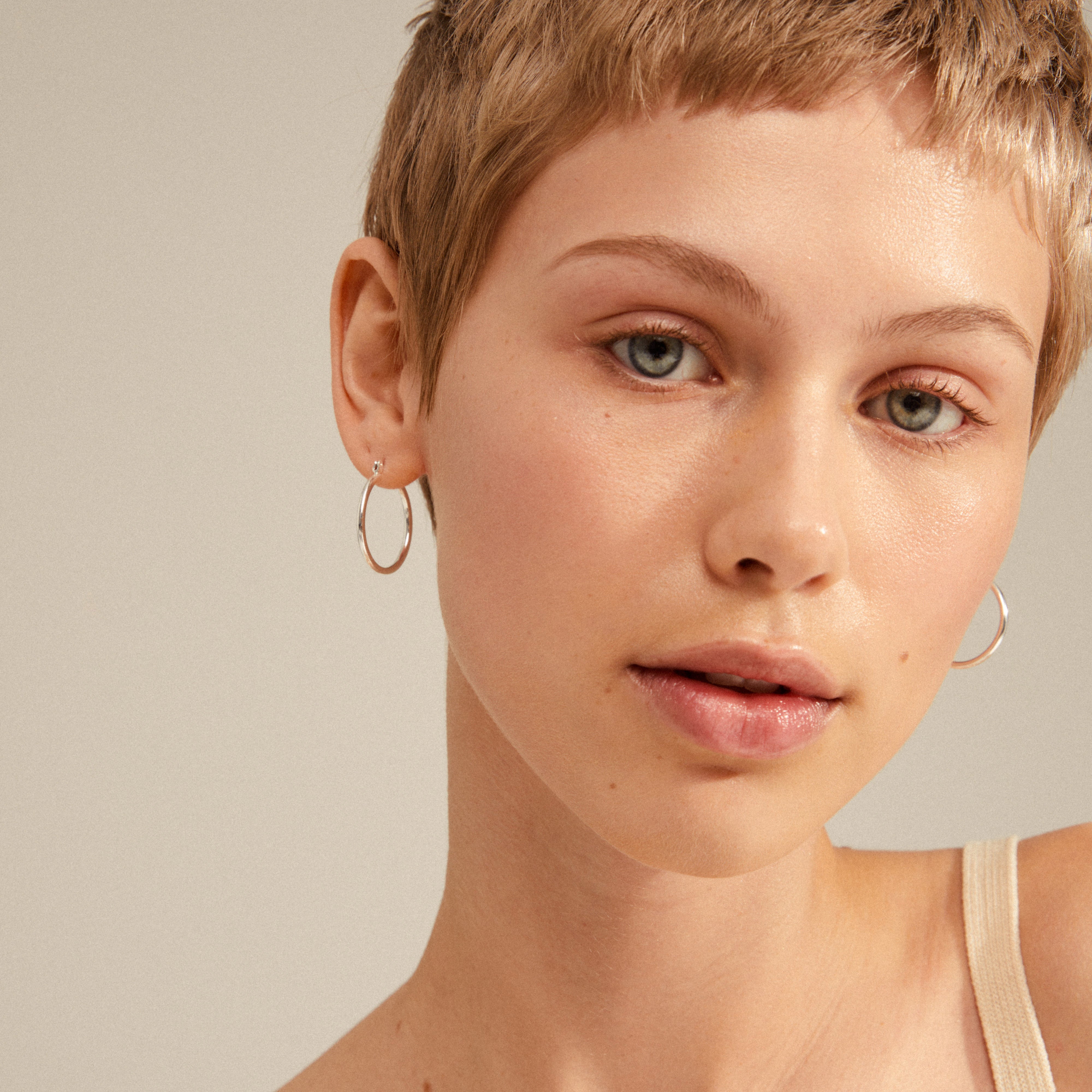 LAYLA medium hoop earrings, silver-plated, worn by a woman with short hair and hoop earrings, highlighting their elegant and timeless design.