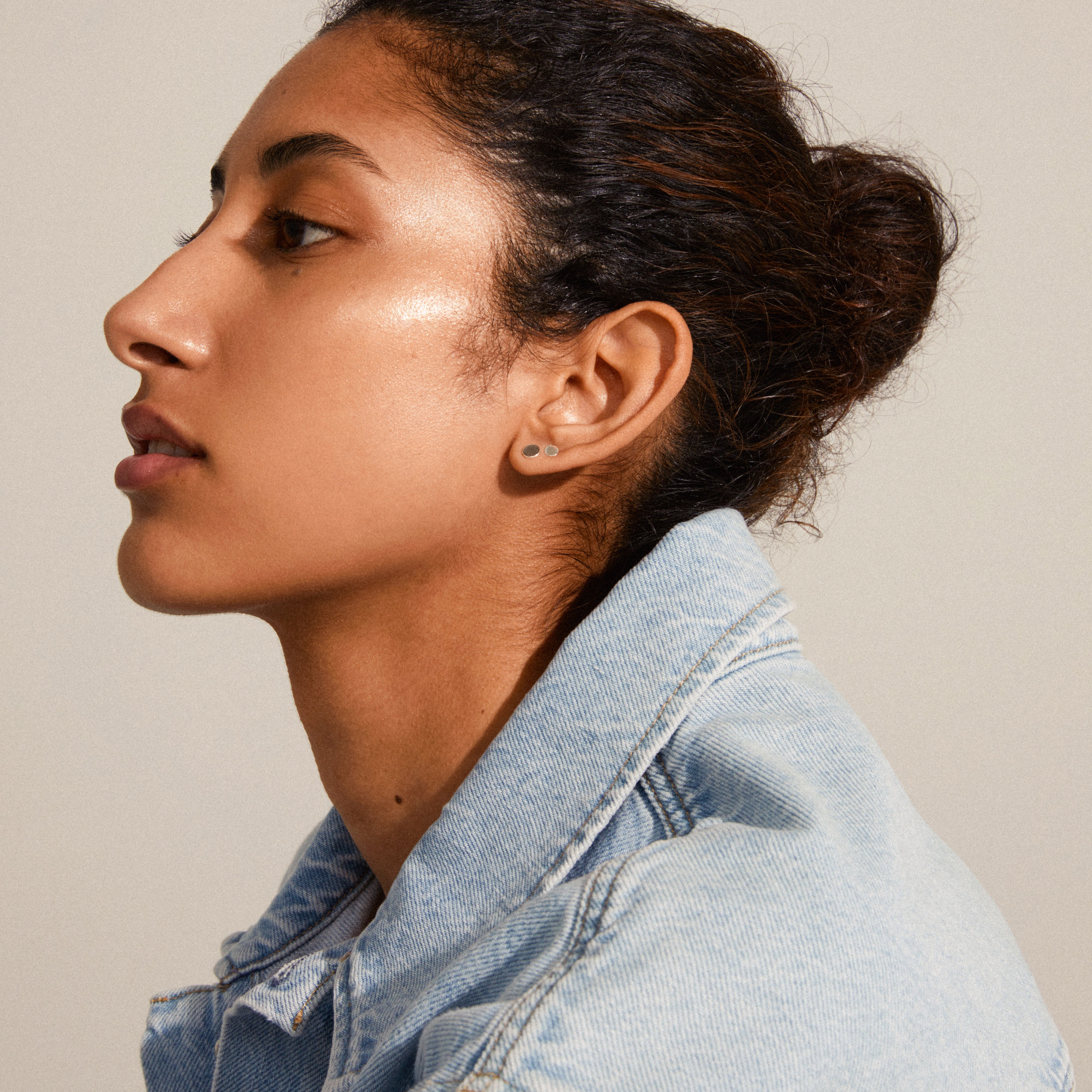 Woman wearing NORMA 3-in-1 silver-plated earrings, showcasing a minimalist style with round studs, perfect for a versatile, stylish look.