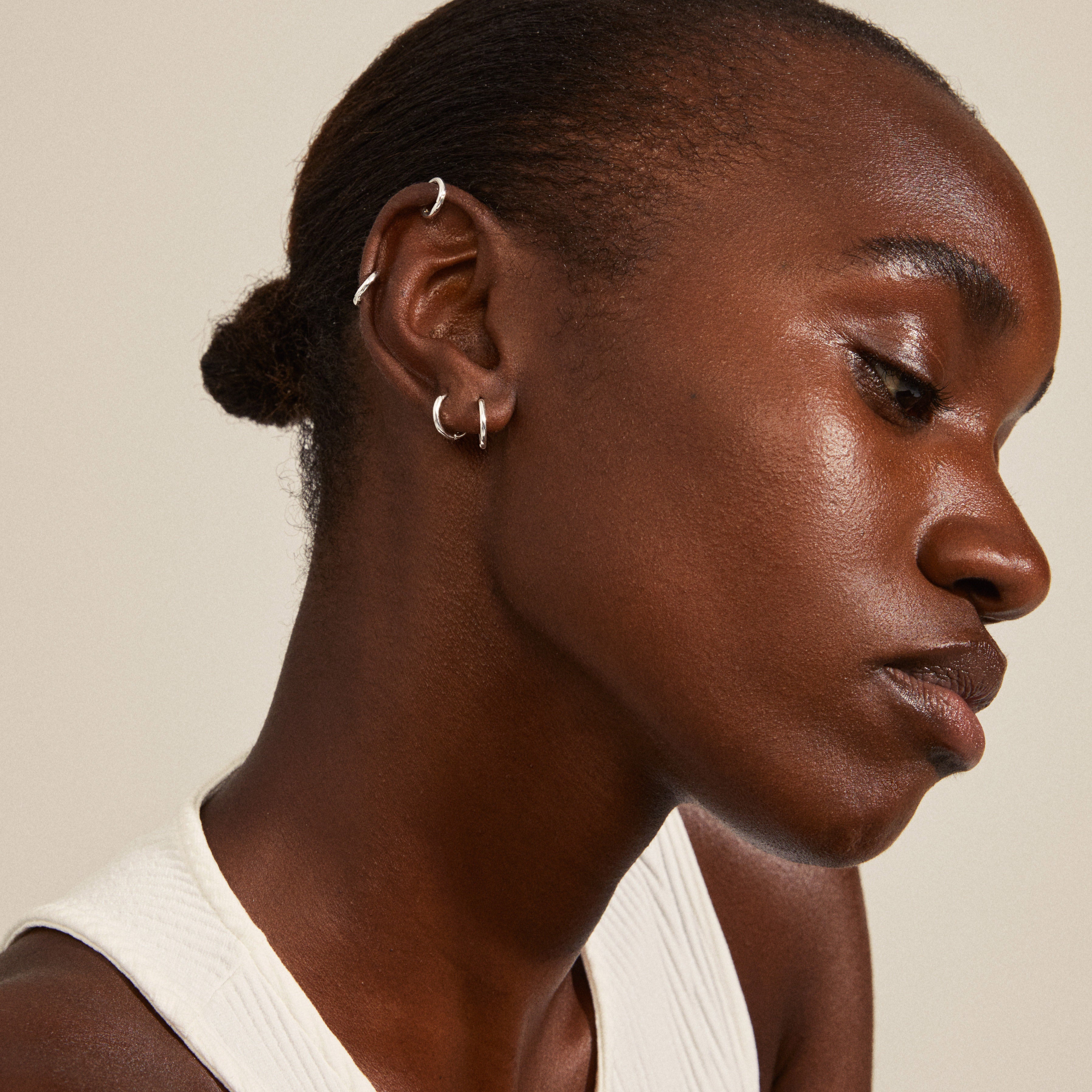 ARIELLA hoop earrings 2-in-1 set silver-plated shown worn by a woman, highlighting the chunky, shiny design of the small huggie hoops.