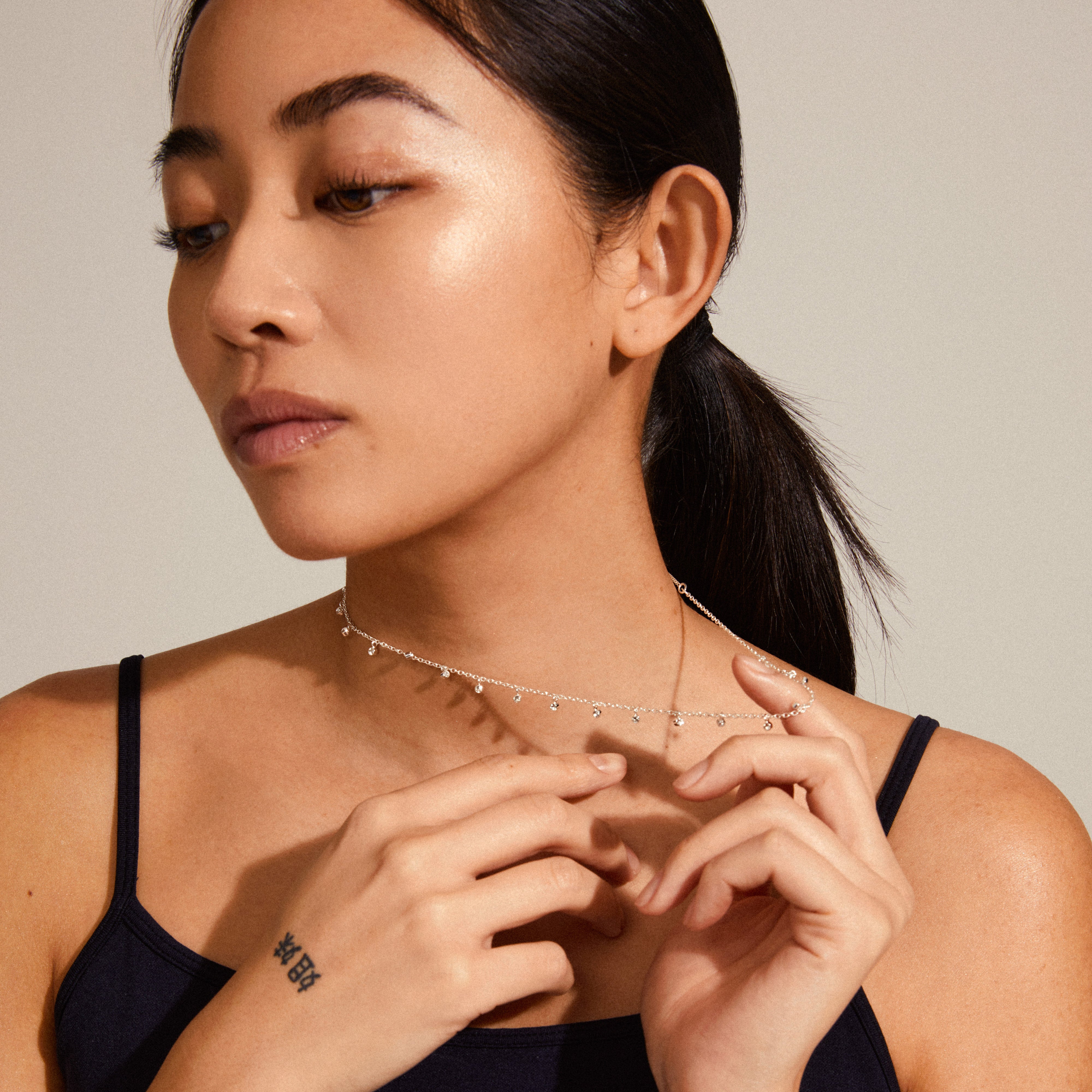MAJA crystal multi drops necklace, silver-plated, displayed on a woman. Features slender curb chain with crystal charms, perfect for layering.