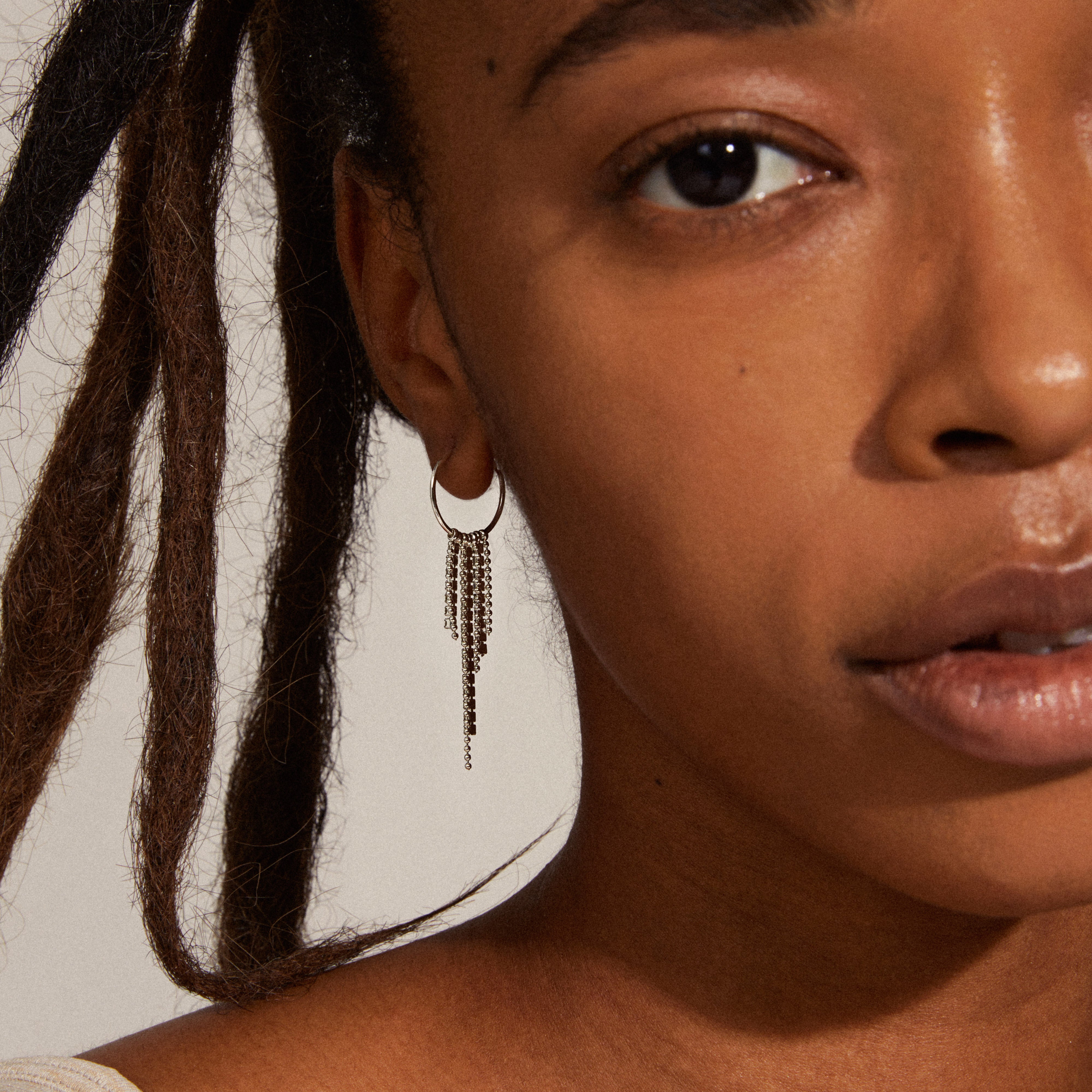 MAJA crystal waterfall hoop earrings in silver-plated design, featuring long, fluttering pendants and crystal chains, exuding a shiny, powerful look.
