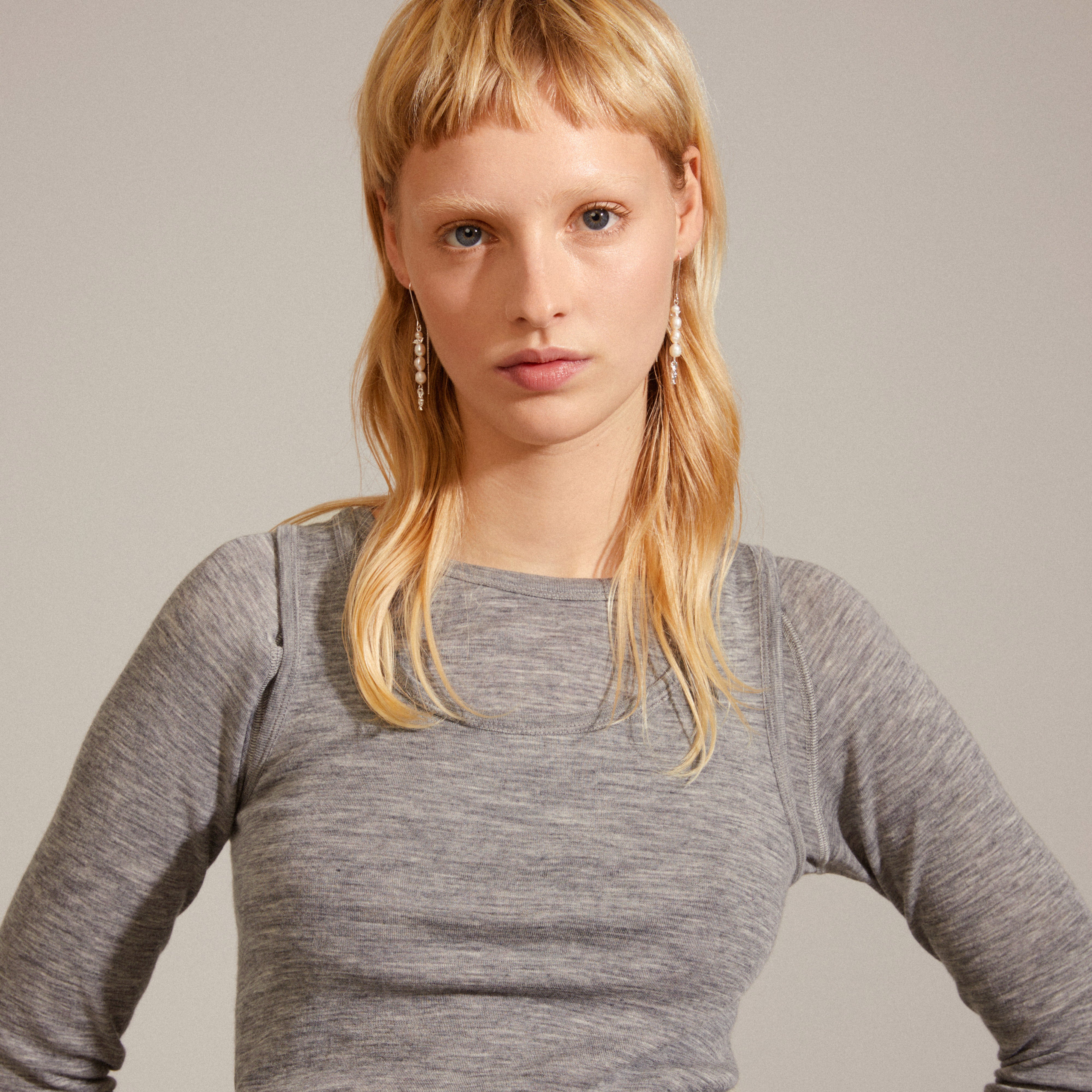 Woman wearing BERTHE pearl chain earrings, silver-plated, featuring genuine freshwater pearls and organic silver-plated details, exemplifying Pilgrim's blend of classic design and natural elegance.