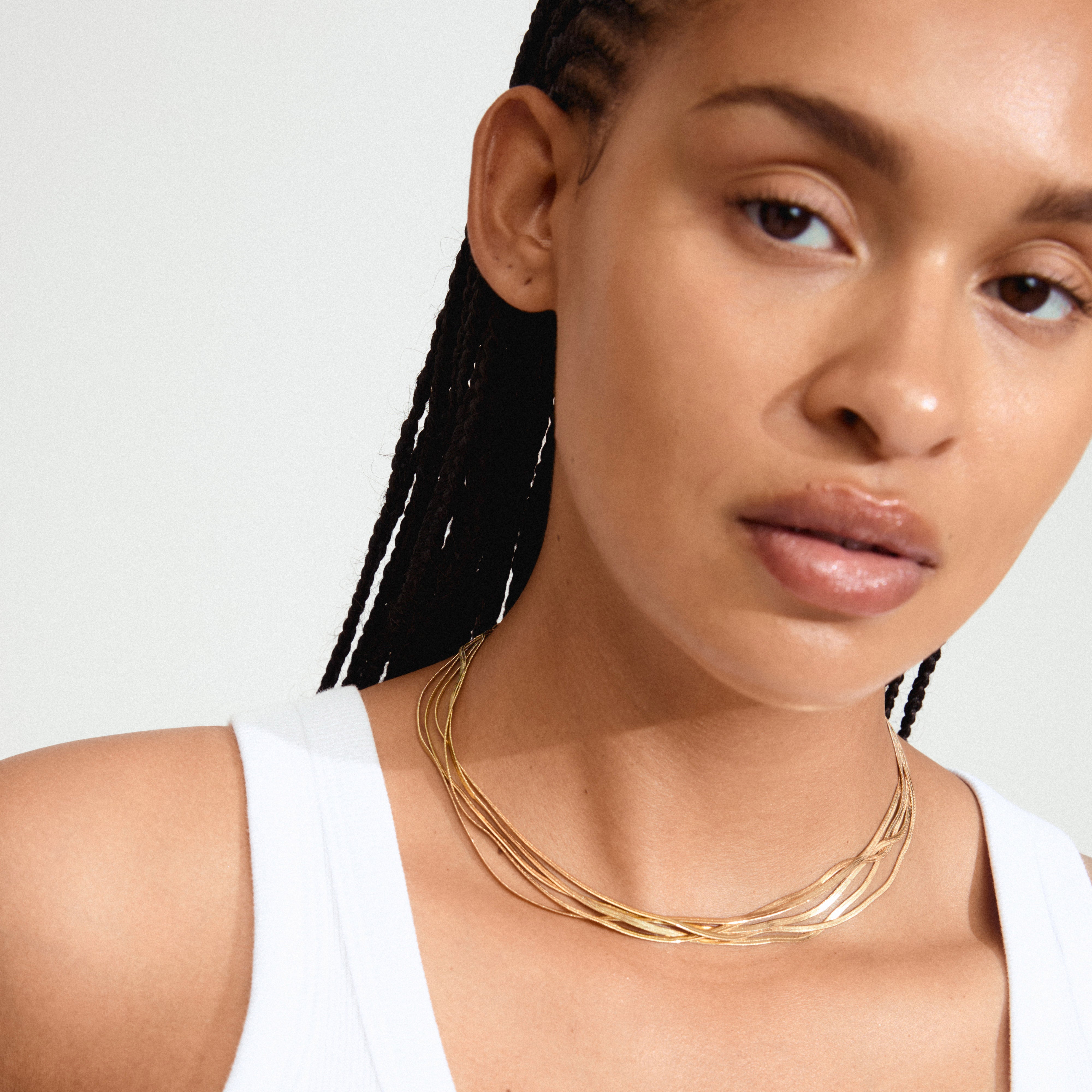 KIRA gold-plated necklace featuring layered flat snake chains, showcasing a bold, sculptural design. Perfect for expressing individual style with Pilgrim’s innovative Danish jewelry.