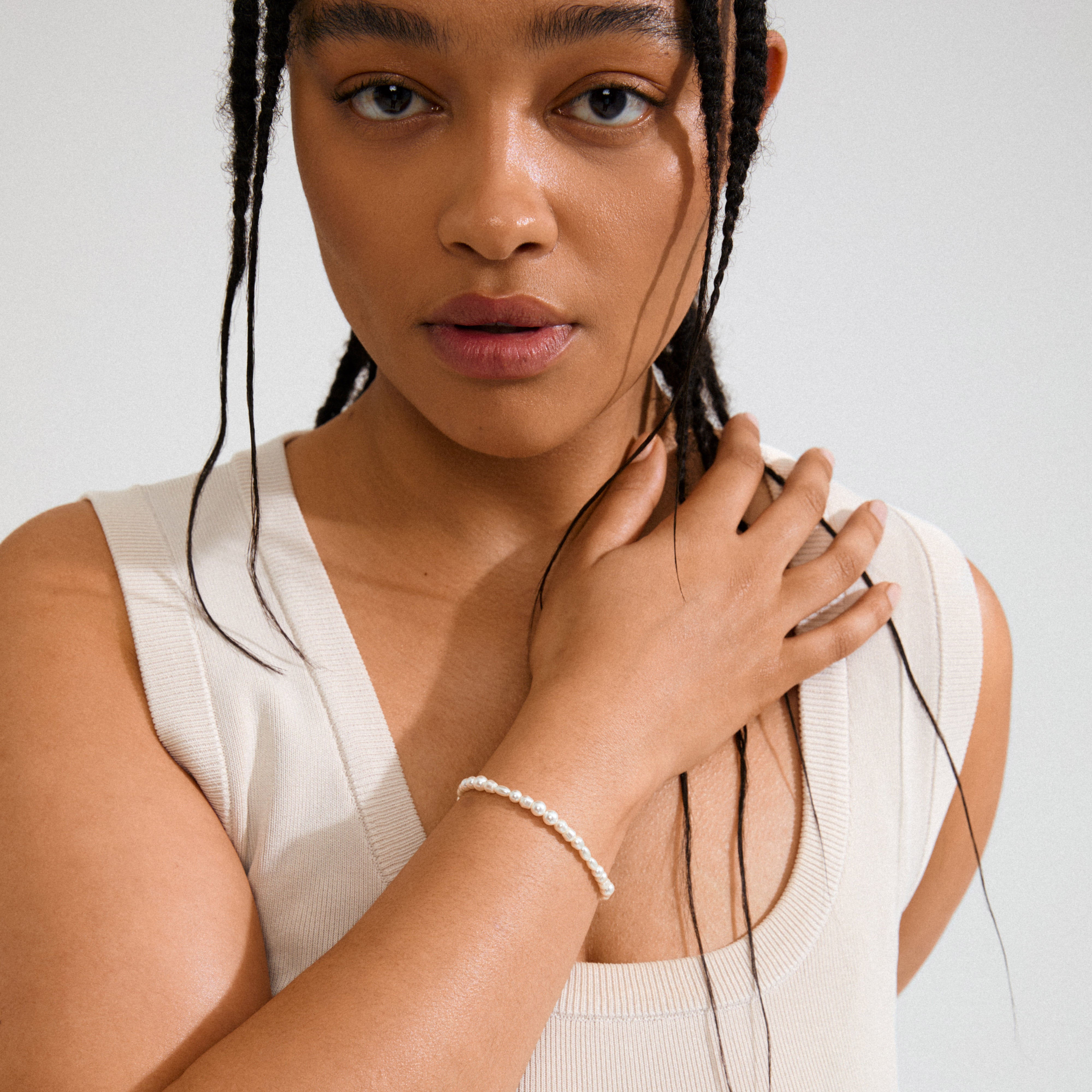 ELLIANA bracelet gold-plated: A close-up of a woman wearing a pearl bracelet, showcasing its elegant freshwater pearls and gold-plated extension for a stylish, timeless look.