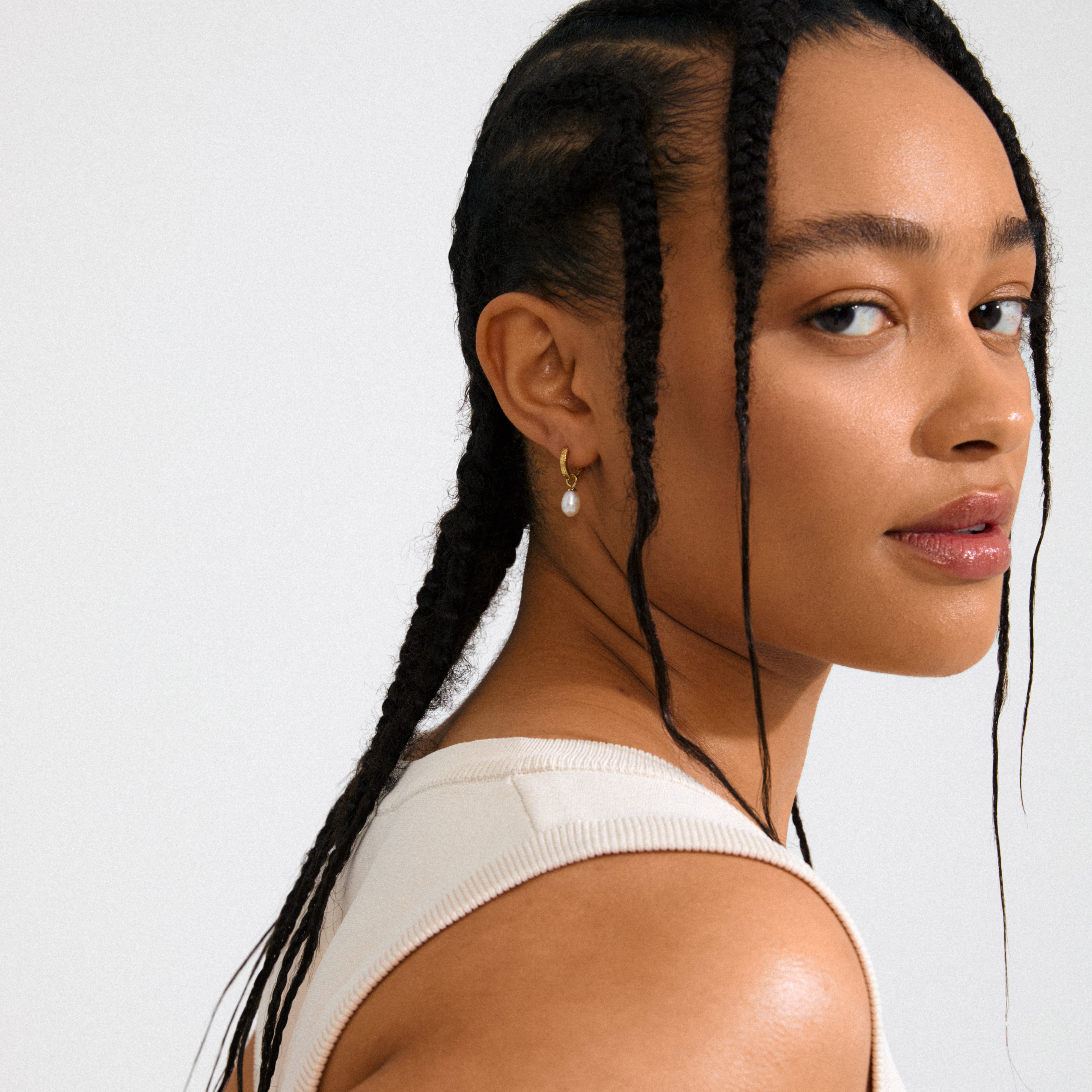 ELLIANA earrings: Gold-plated hoops with braided texture, featuring genuine freshwater pearls. Stylish, versatile design with click clasps, ideal for adding luxury to any outfit.