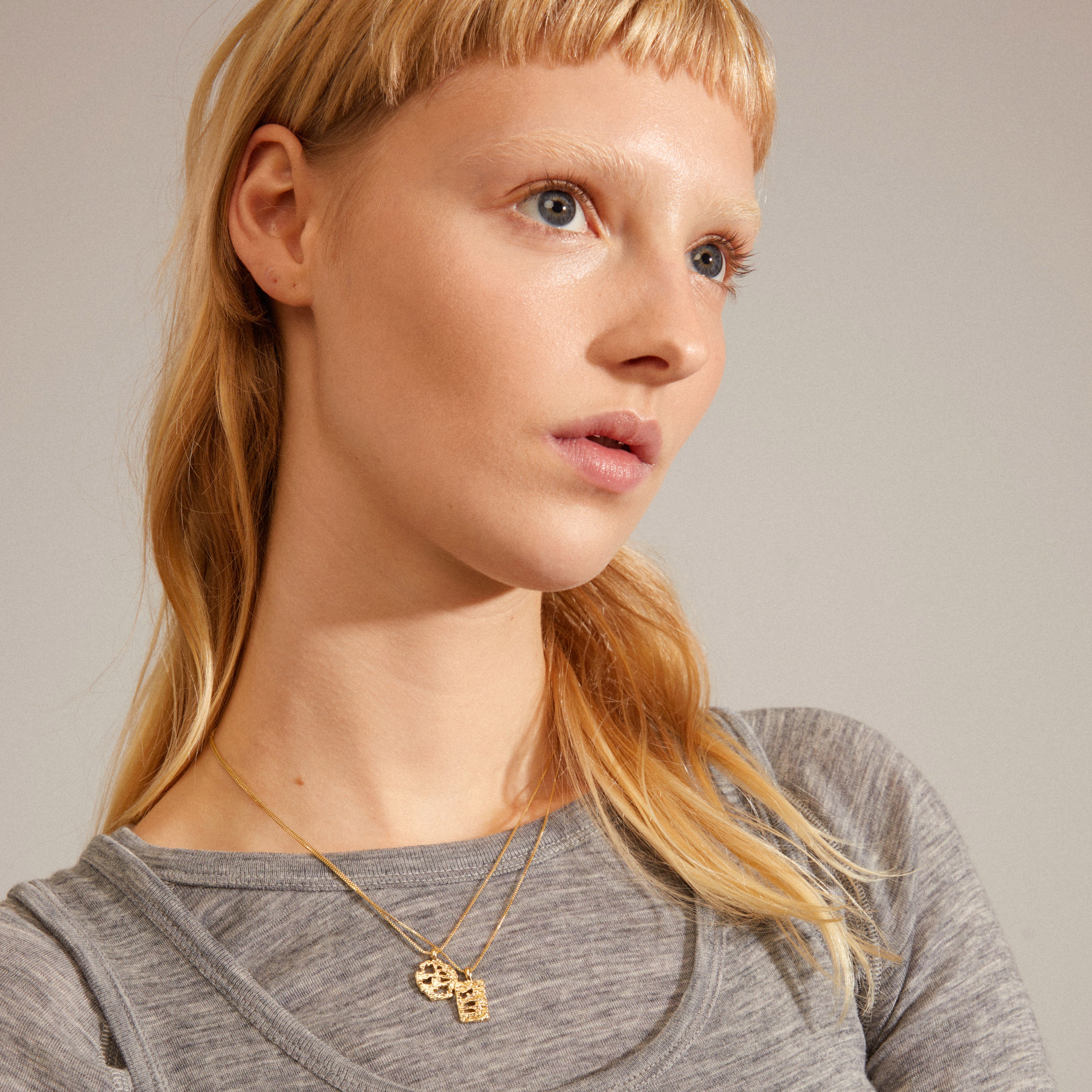 BRENDA pendant necklace 2-in-1 set gold-plated, worn by a woman with blonde hair, featuring two coin chains, highlighting Pilgrim's handcrafted Danish design.