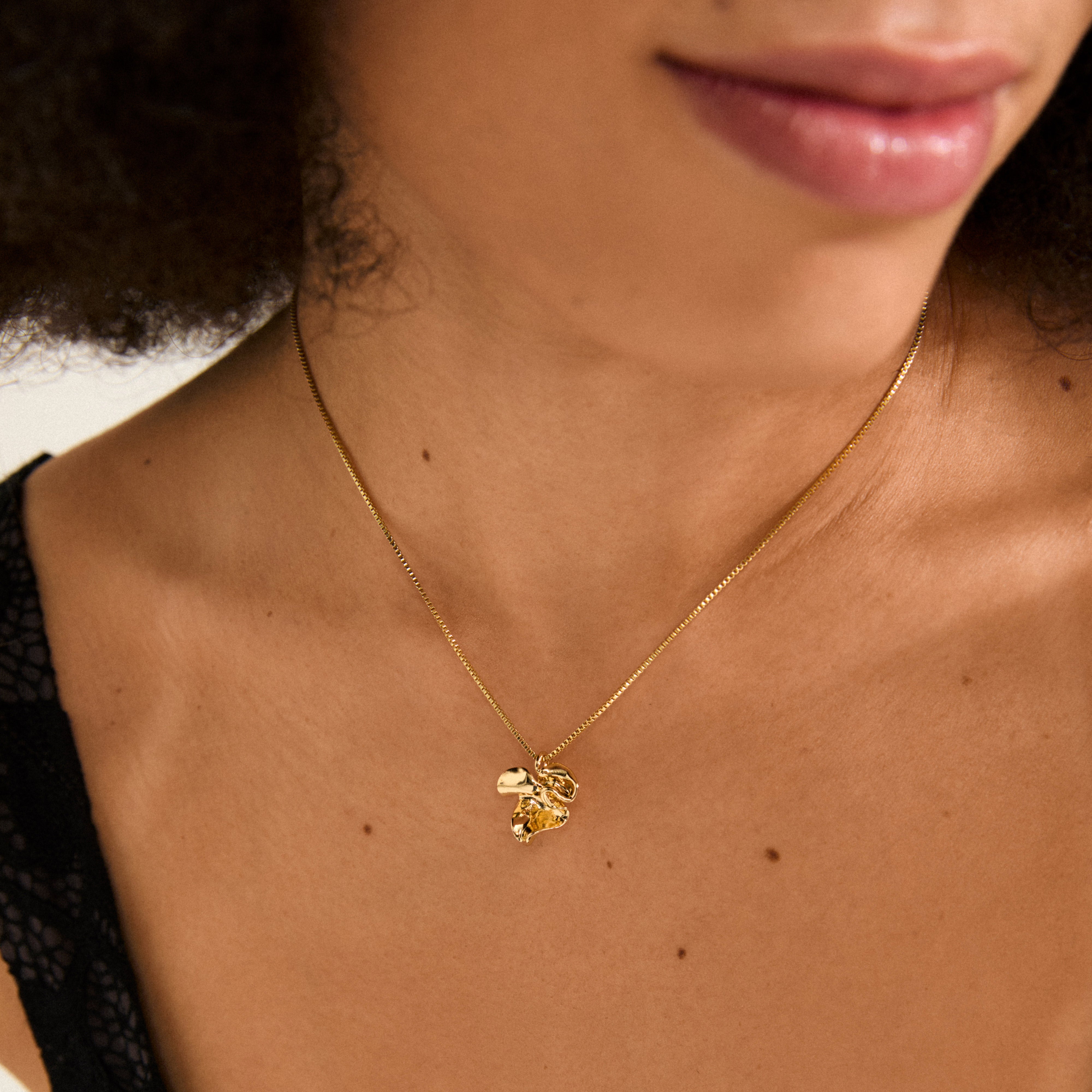 LUIS necklace gold-plated by Pilgrim features a sleek box chain with an abstract flower pendant, adaptable length for minimalist or layered styles.