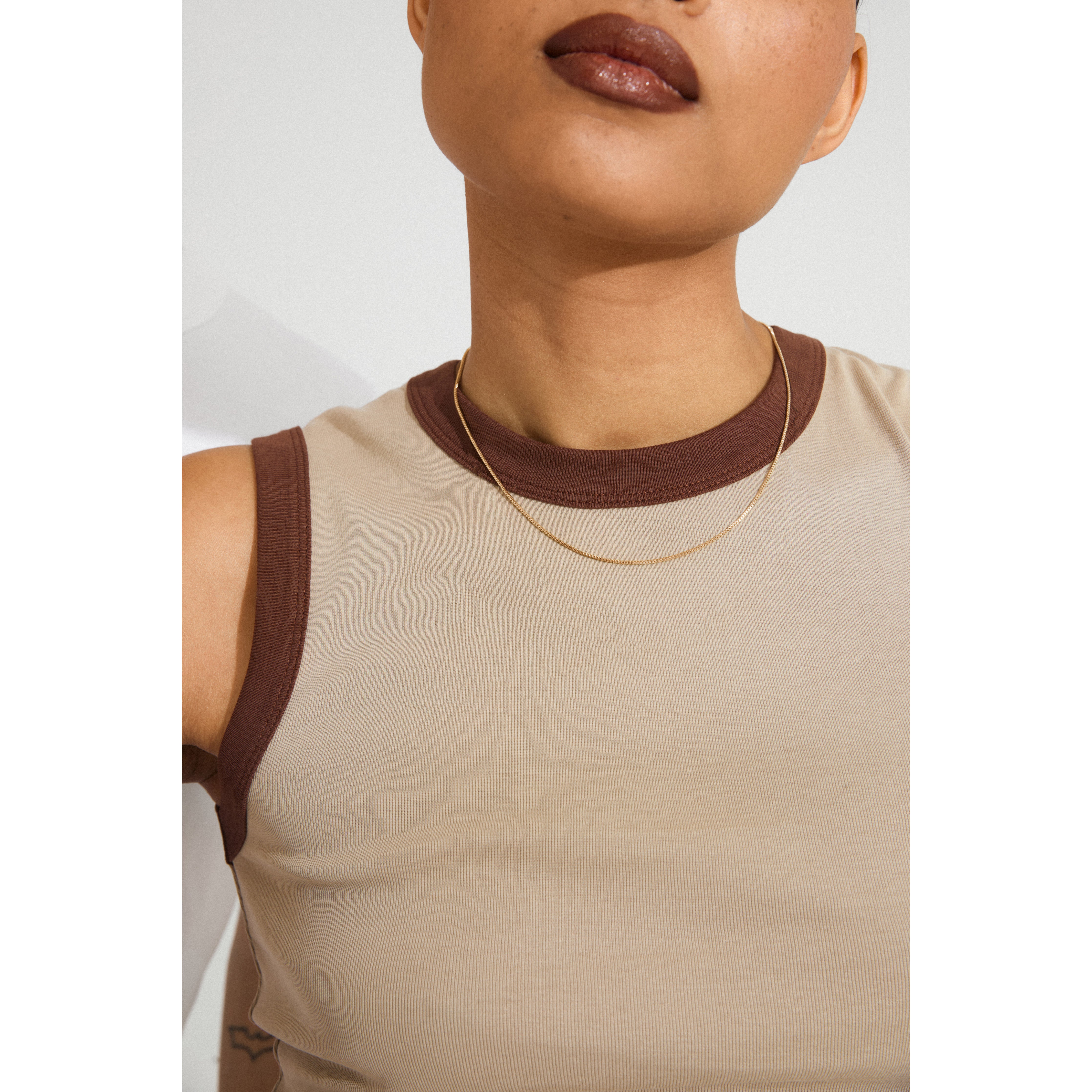 Close-up of a woman's neck wearing the NANCY necklace, a 45 cm rose gold-plated Venezia chain, perfect for layering or adding a pendant.