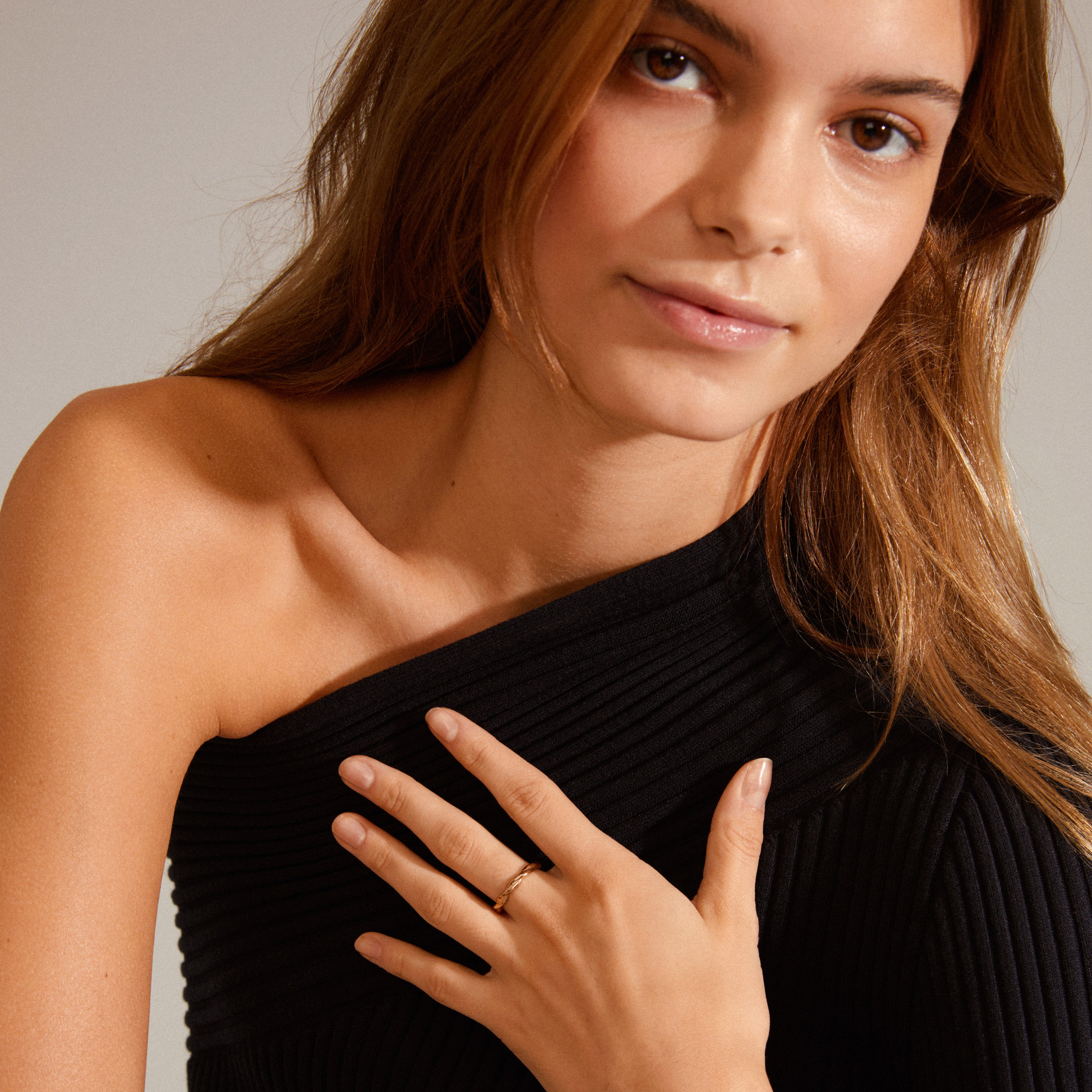 Close-up of a woman's hand wearing a LULU twirl stack ring, gold-plated, highlighting its angular design, part of Pilgrim's stylish stacking ring collection.