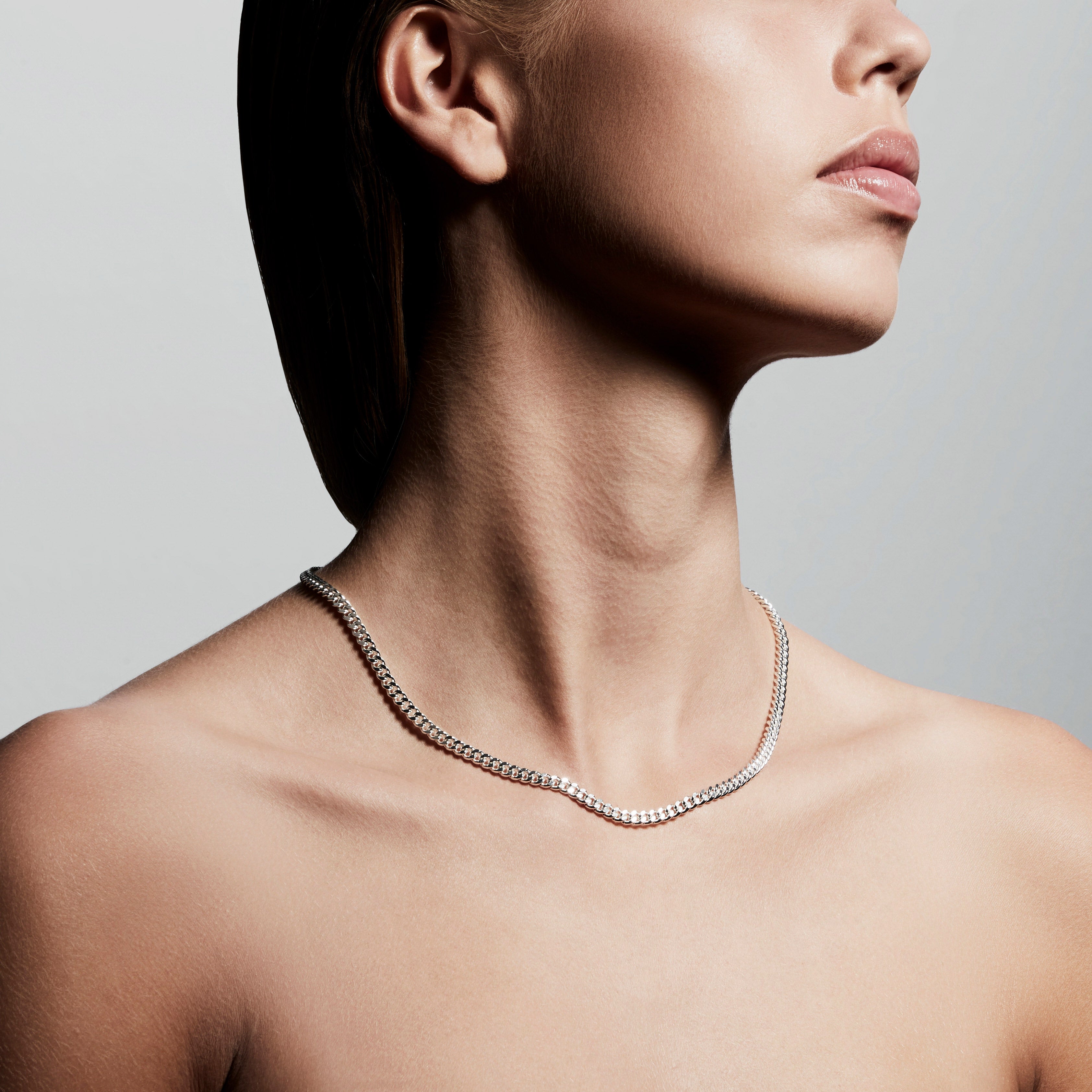 FUCHSIA curb chain necklace, silver-plated, displayed on a woman's neck, showcasing its elegant design from Pilgrim's Classic collection, measuring 40 + 9 cm.