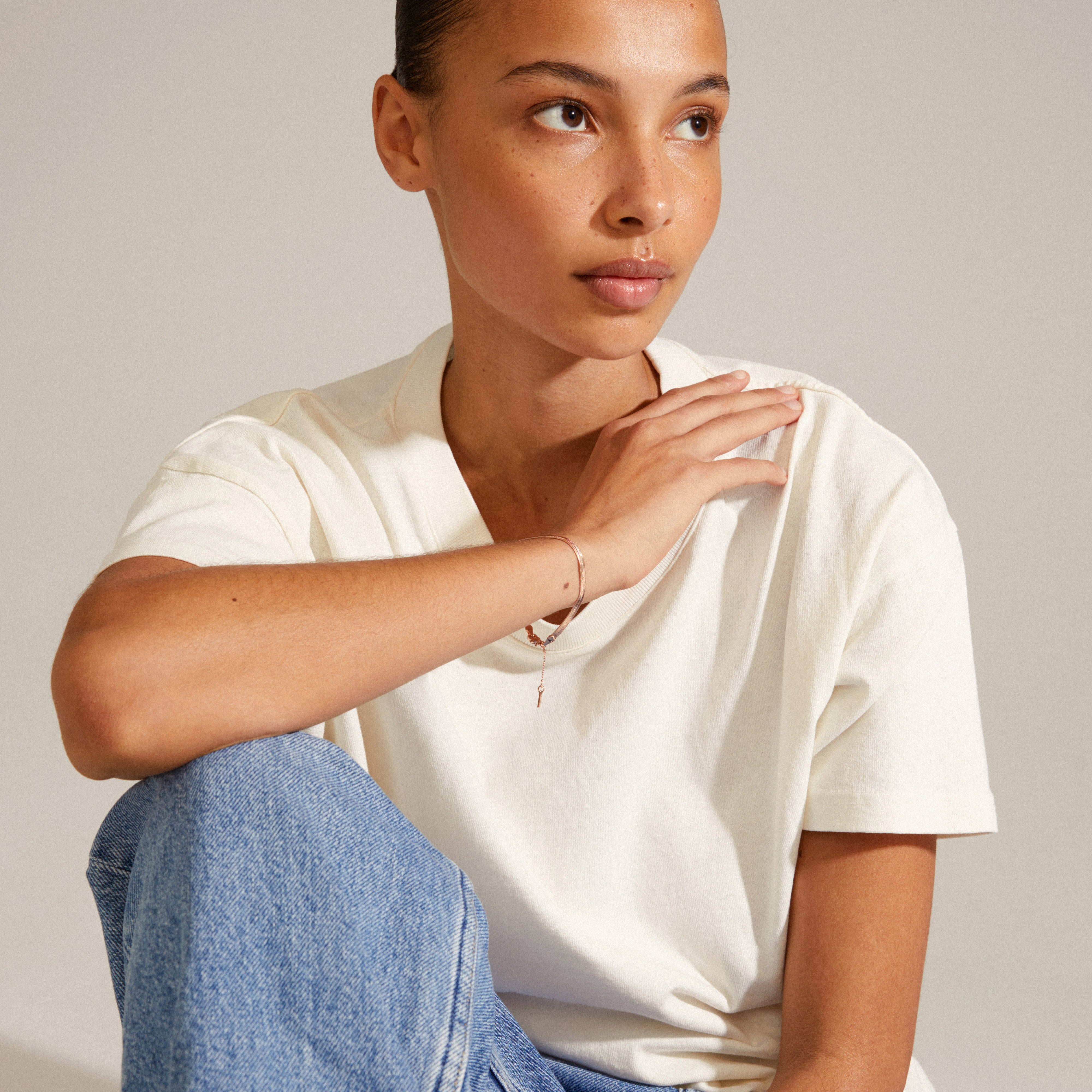 JOANNA flat snake chain bracelet in rose gold-plated design, worn by a woman, showcasing its stylish weight and extension chain with Pilgrim tag.