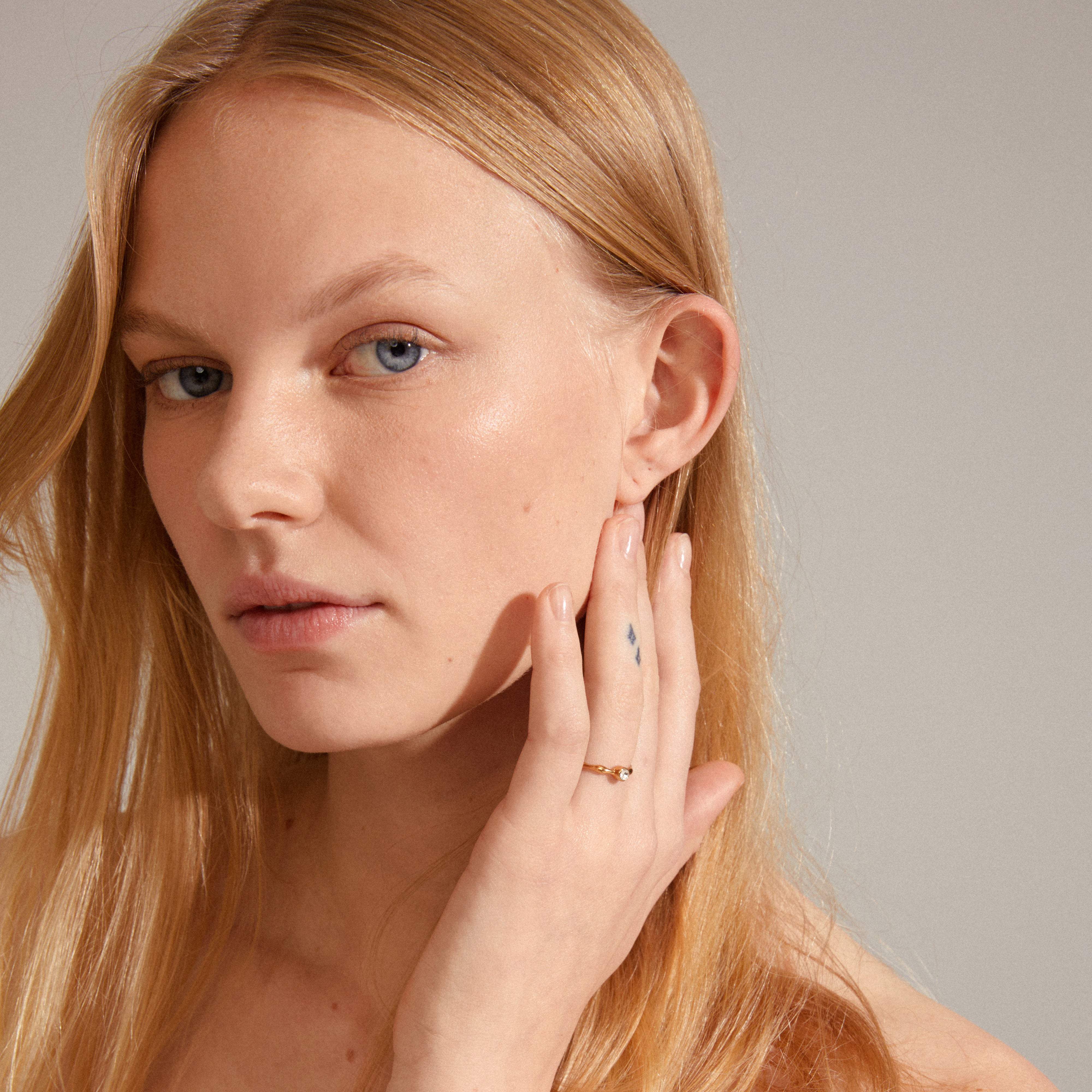LULU crystal stack ring gold-plated, showcasing a wavy design with a sparkling Preciosa crystal, elegantly worn on a woman's hand.