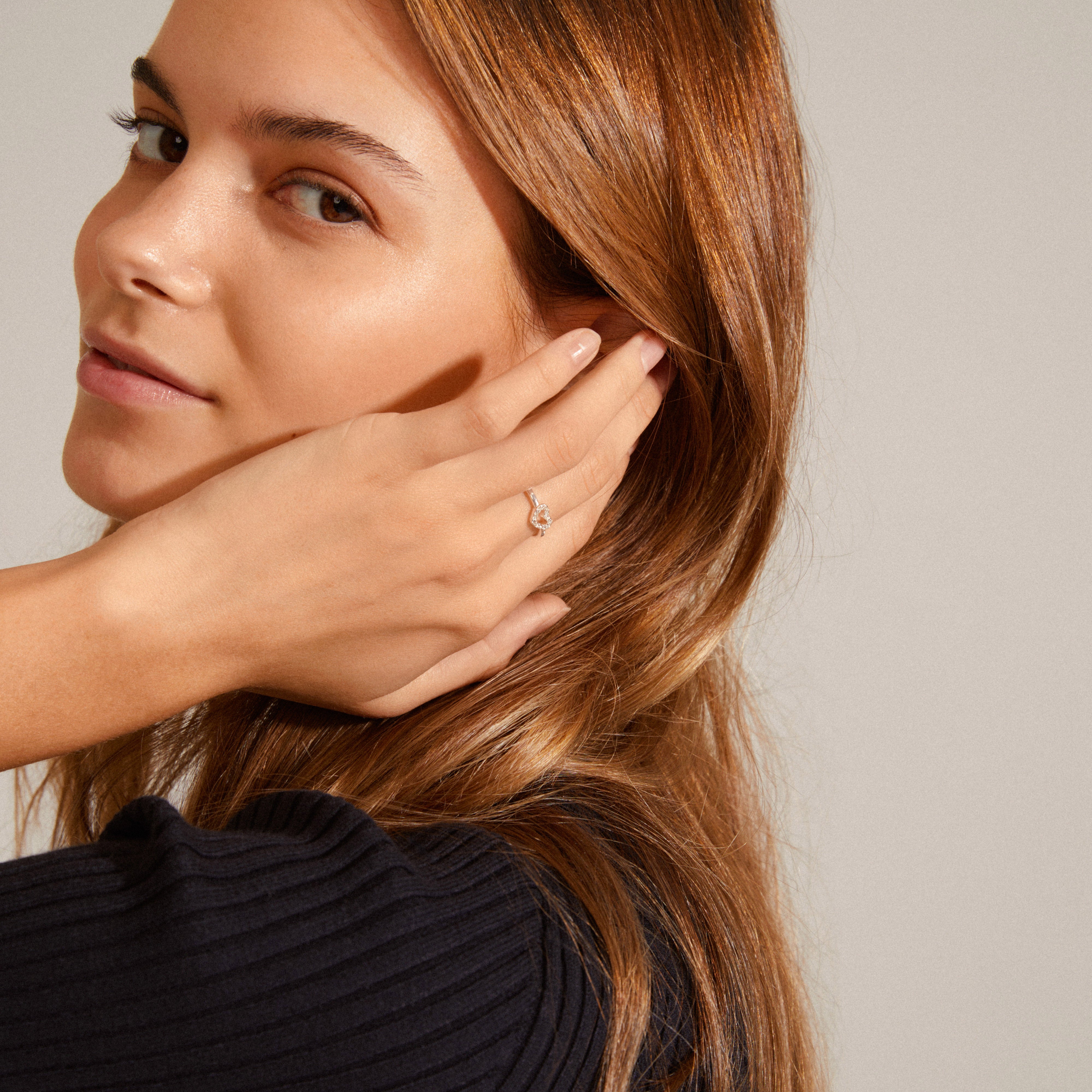 LULU crystal heart stack ring silver-plated, adorned with Preciosa crystals, displayed on a woman's hand touching her face, emphasizing elegance and simplicity.