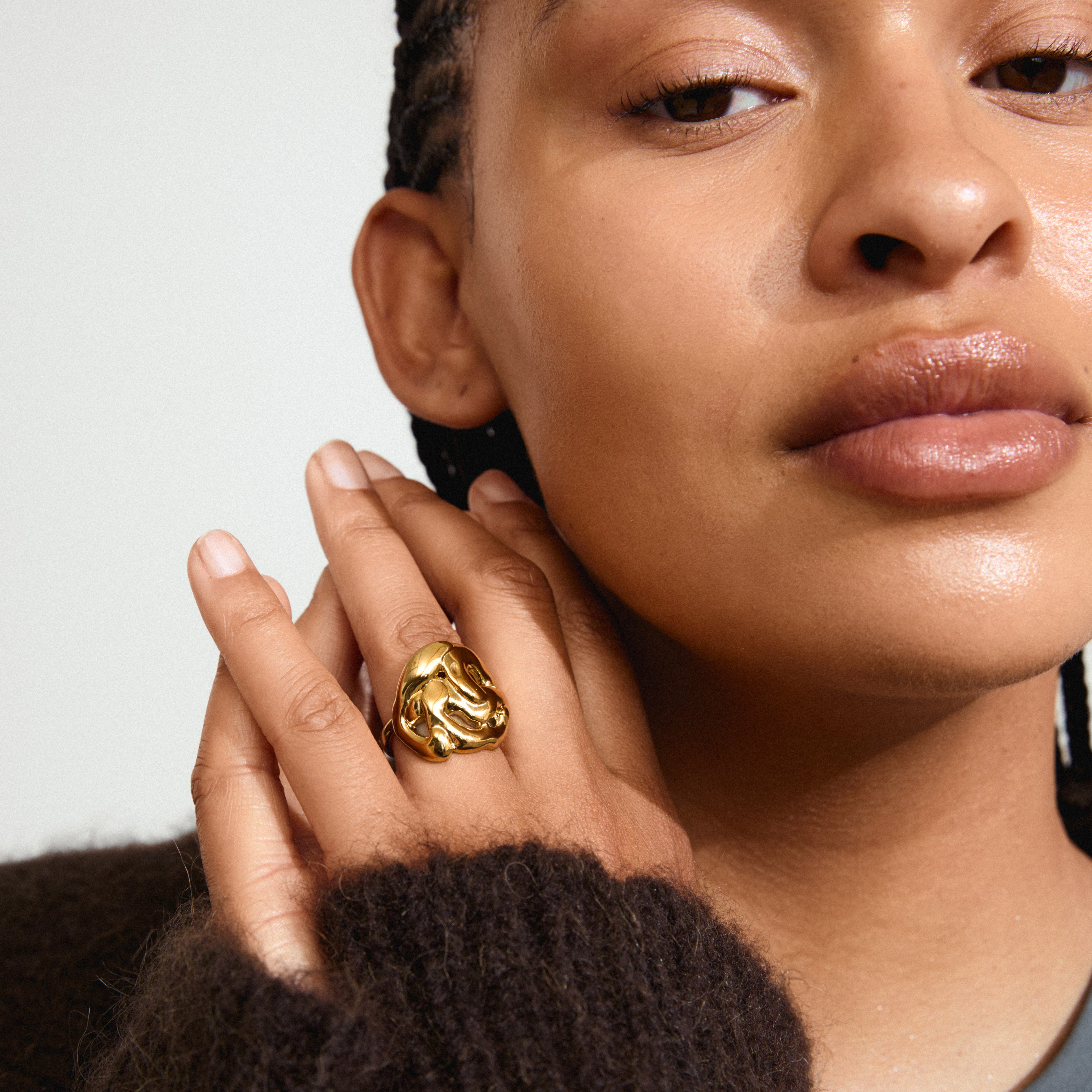 LUCA gold-plated ring on a woman's finger, showcasing its unique, handcrafted bohemian design with organic shapes and a melting look.