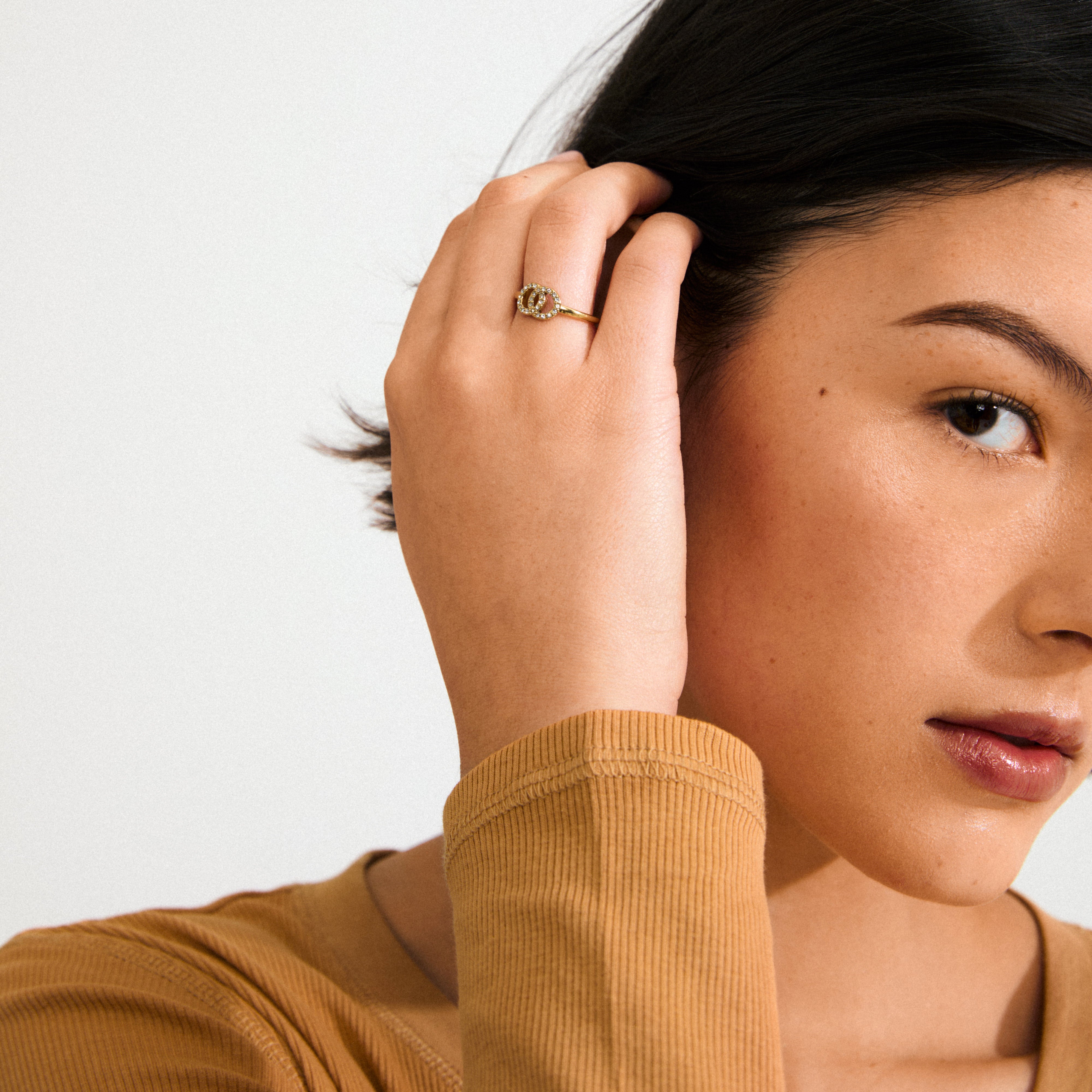 LULU halos stack ring gold-plated featuring two intertwined, crystal-adorned circles symbolizing connection and balance, crafted from 93% recycled material for an elegant, chic look.