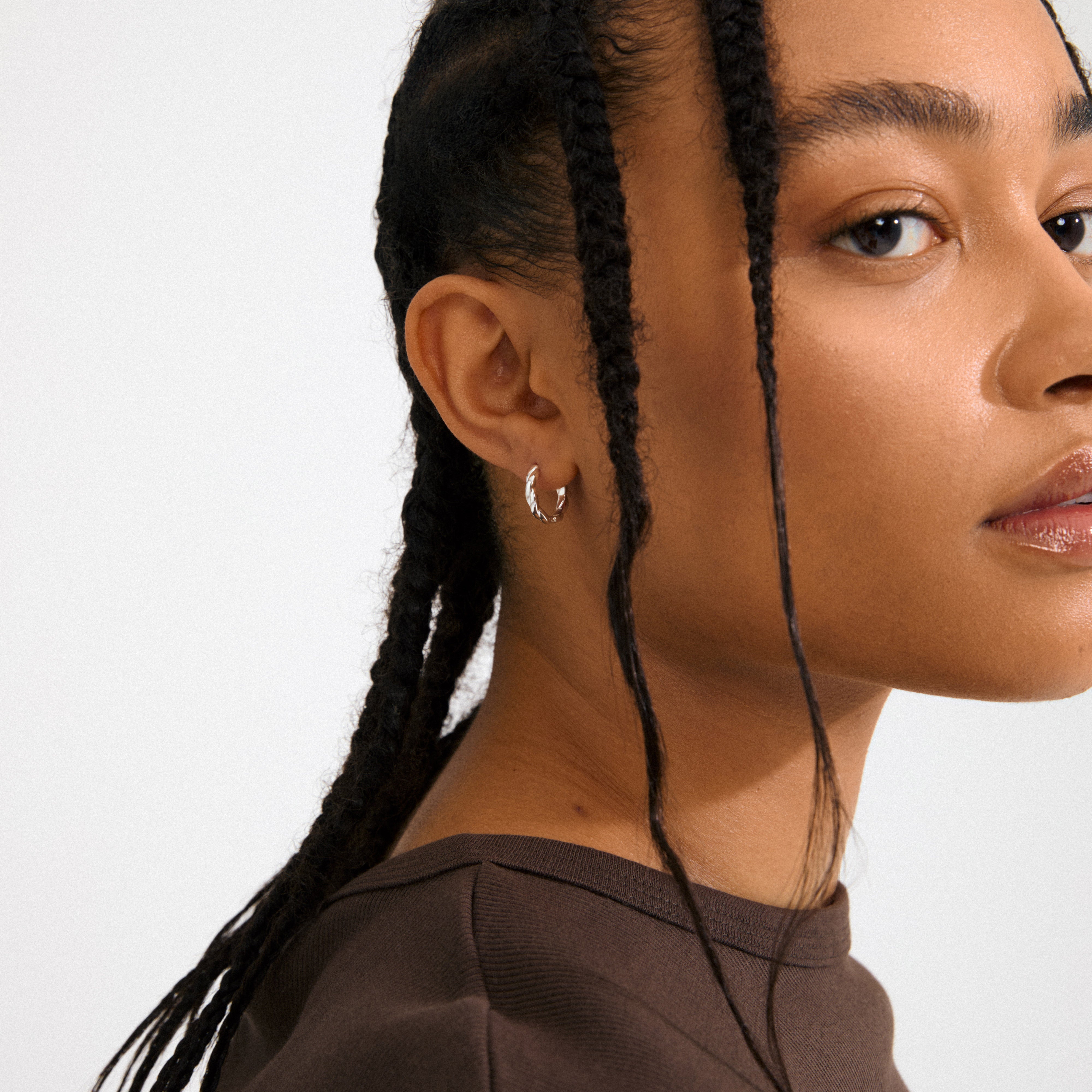DECLAN silver-plated hoops with twisted design and click clasps, crafted from 99% recycled materials, offering timeless style and versatility for any outfit.