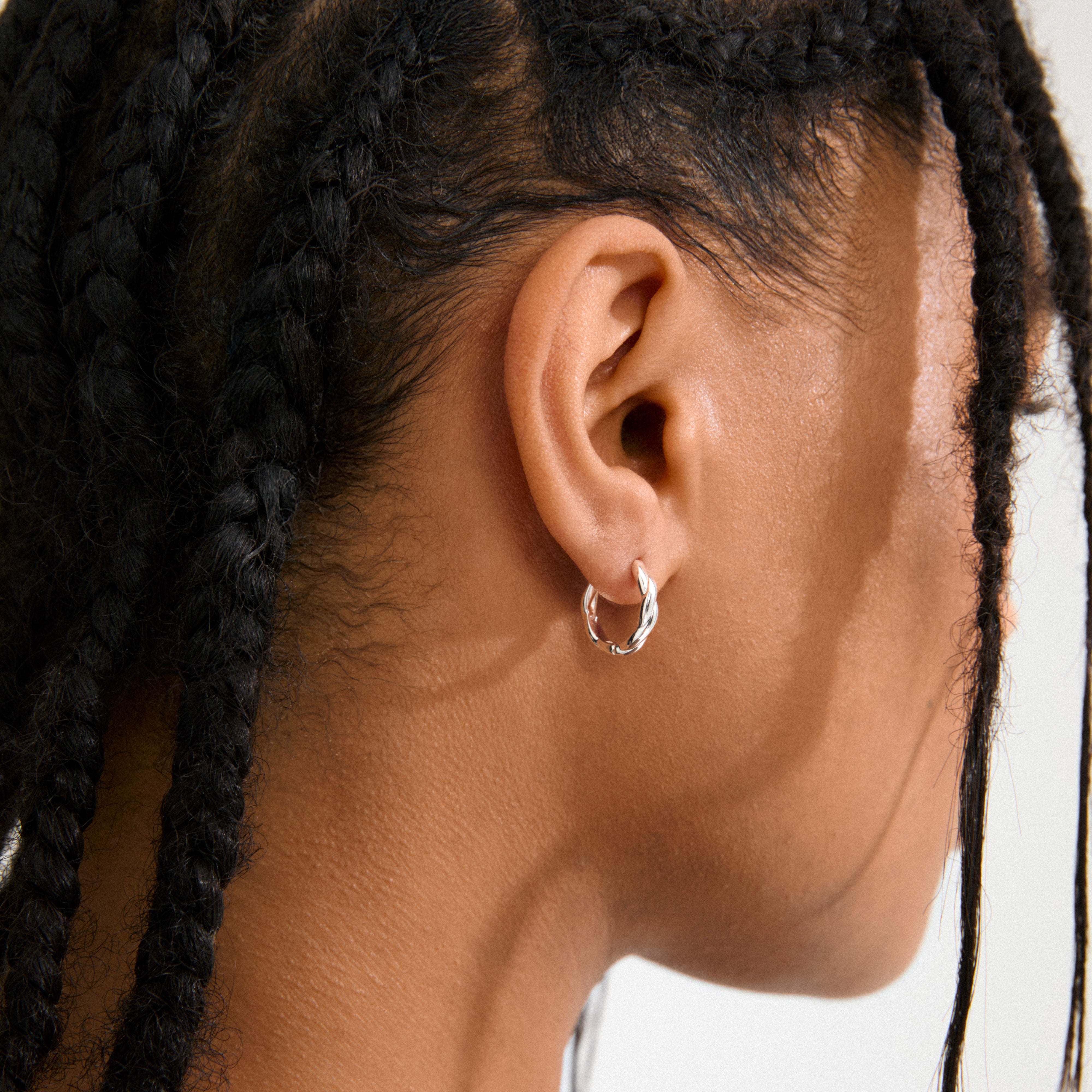 DECLAN earrings silver-plated with twisted design and click clasps, crafted from 99% recycled materials, showcasing Pilgrim's blend of timeless and trendy Scandinavian style.