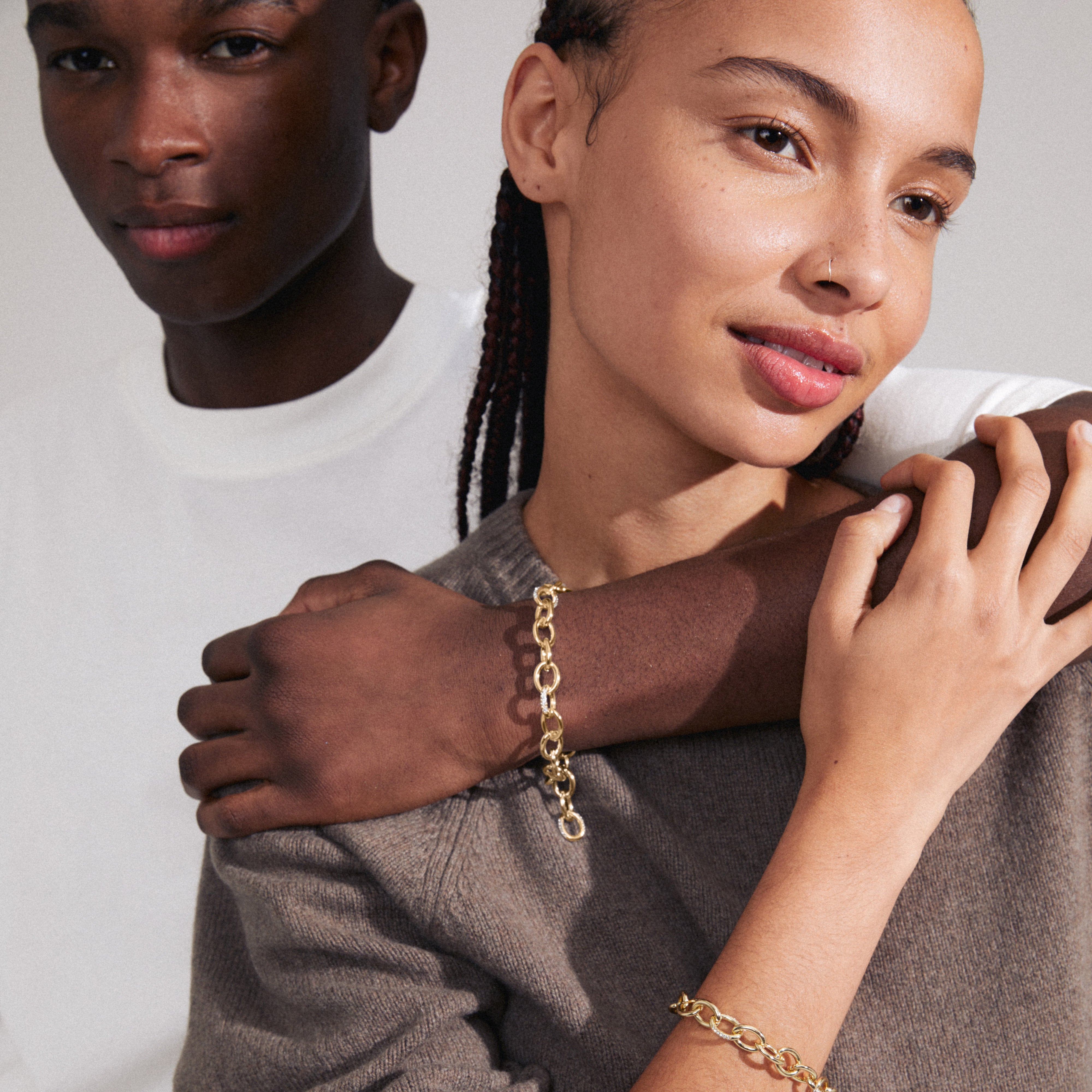 AMIRI bracelet gold-plated with sparkling Preciosa crystals, showcasing an open, fluid design on a wrist, emphasizing its genderless, urban style.