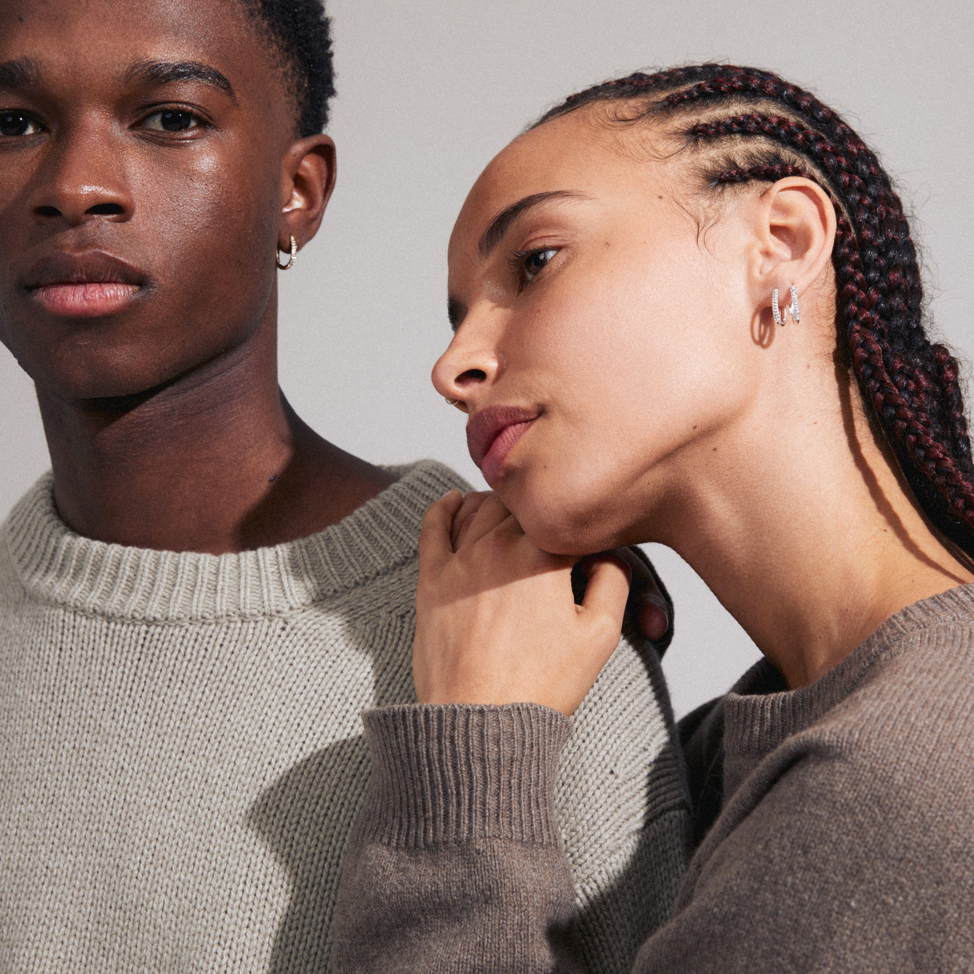 AMIRI silver-plated earrings with sparkling Preciosa crystals worn by a woman with braids, showcasing their elegant oval design and easy-to-use click clasp.