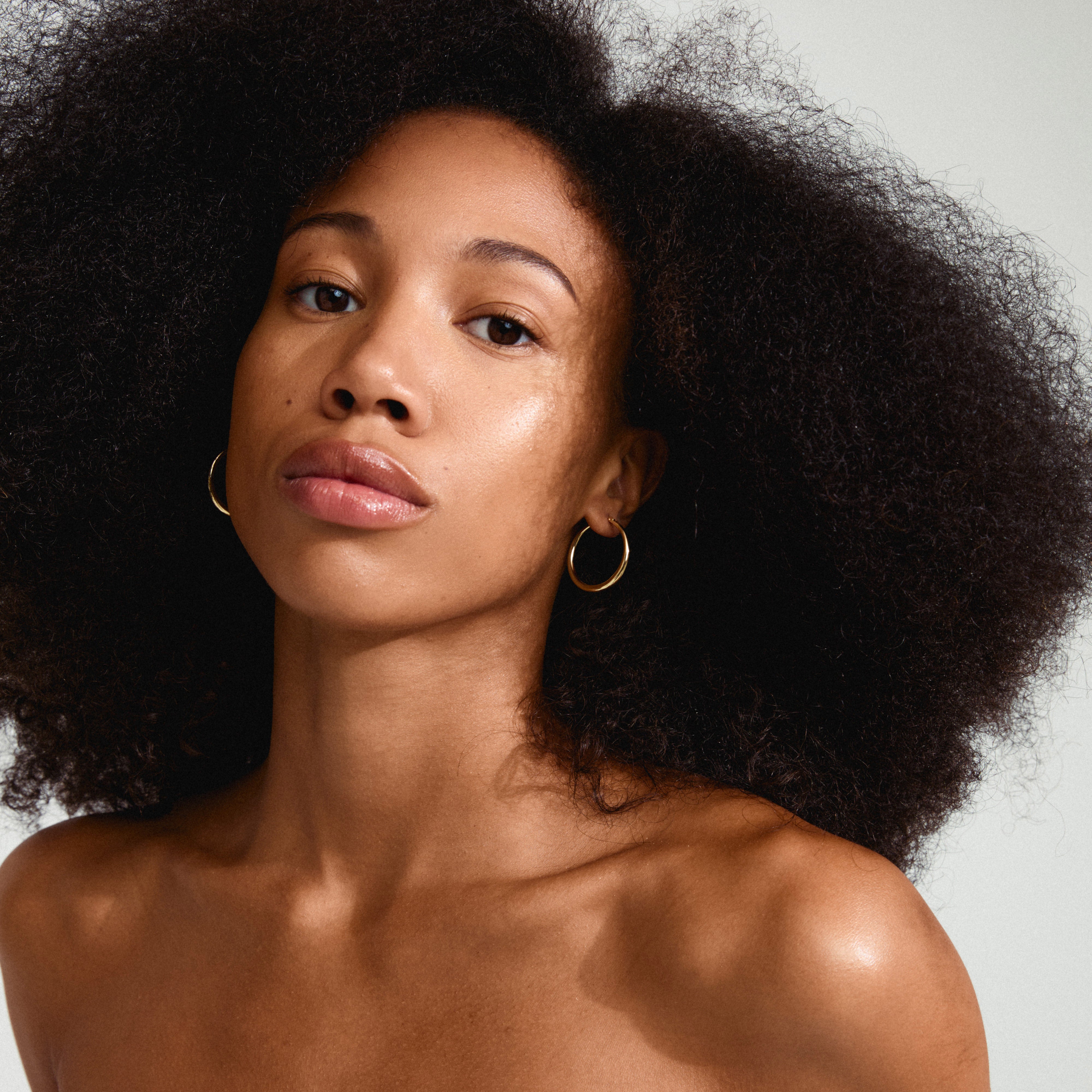 JORUN hoop earrings gold-plated showcased by a woman with big afro hair, highlighting their classic 30mm design as a timeless, versatile accessory.