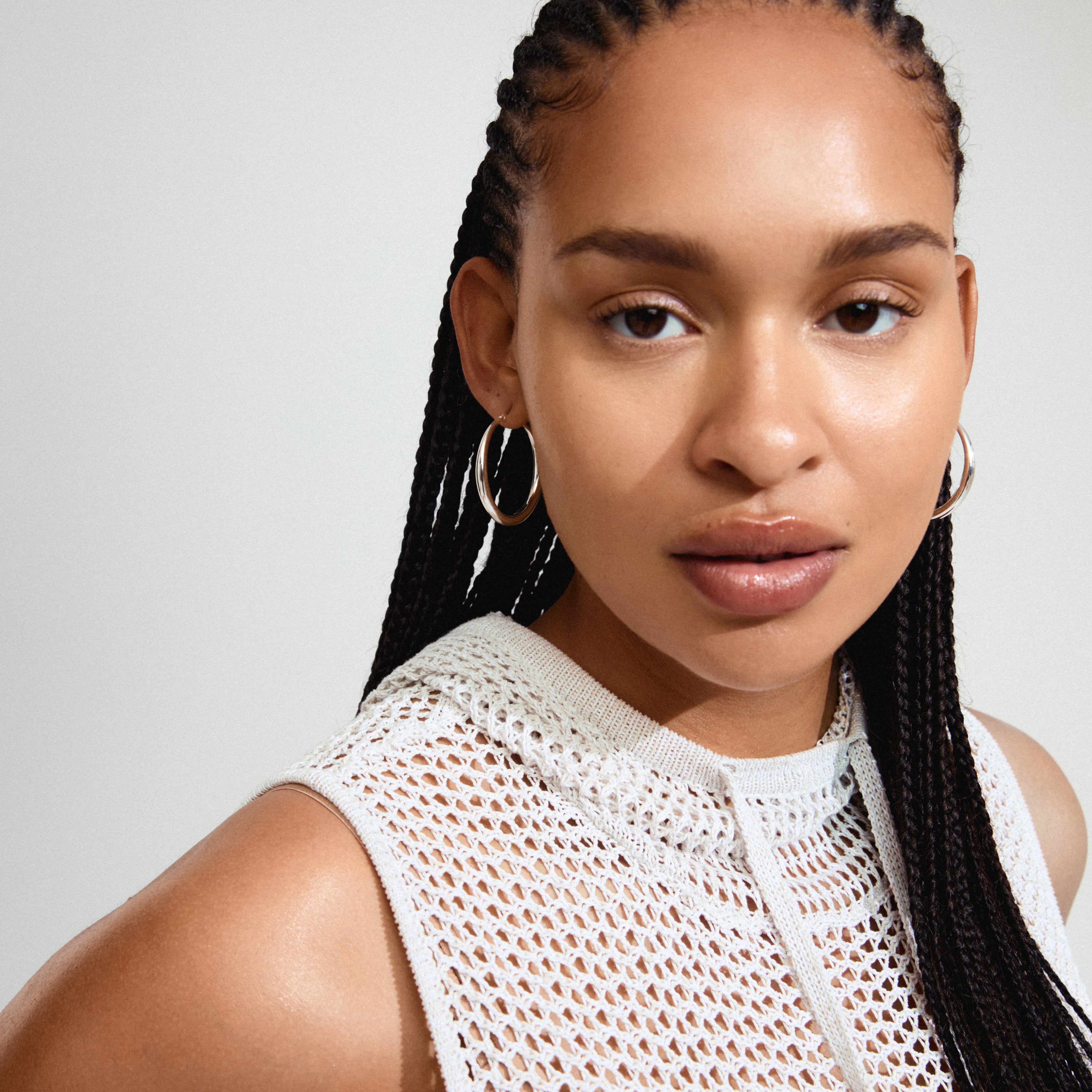 JORUN large hoop earrings silver-plated worn by woman with braided hair, showcasing their classic design and 40mm diameter, ideal for versatile, trendy styling.