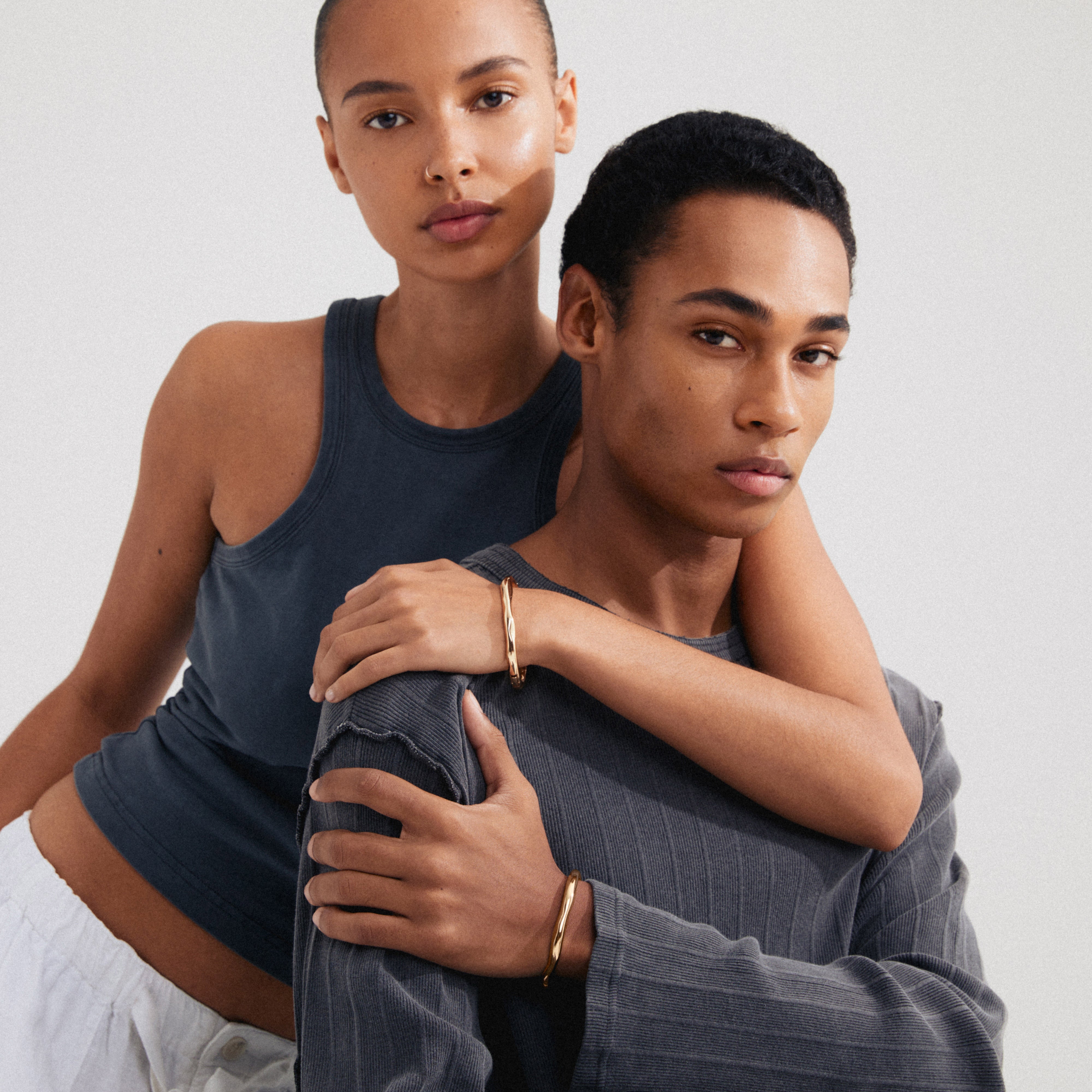 Gold-plated HARRISON bangle with wavy design, a stylish Scandinavian piece from Pilgrim. Features a click clasp and is made from 99% recycled material.