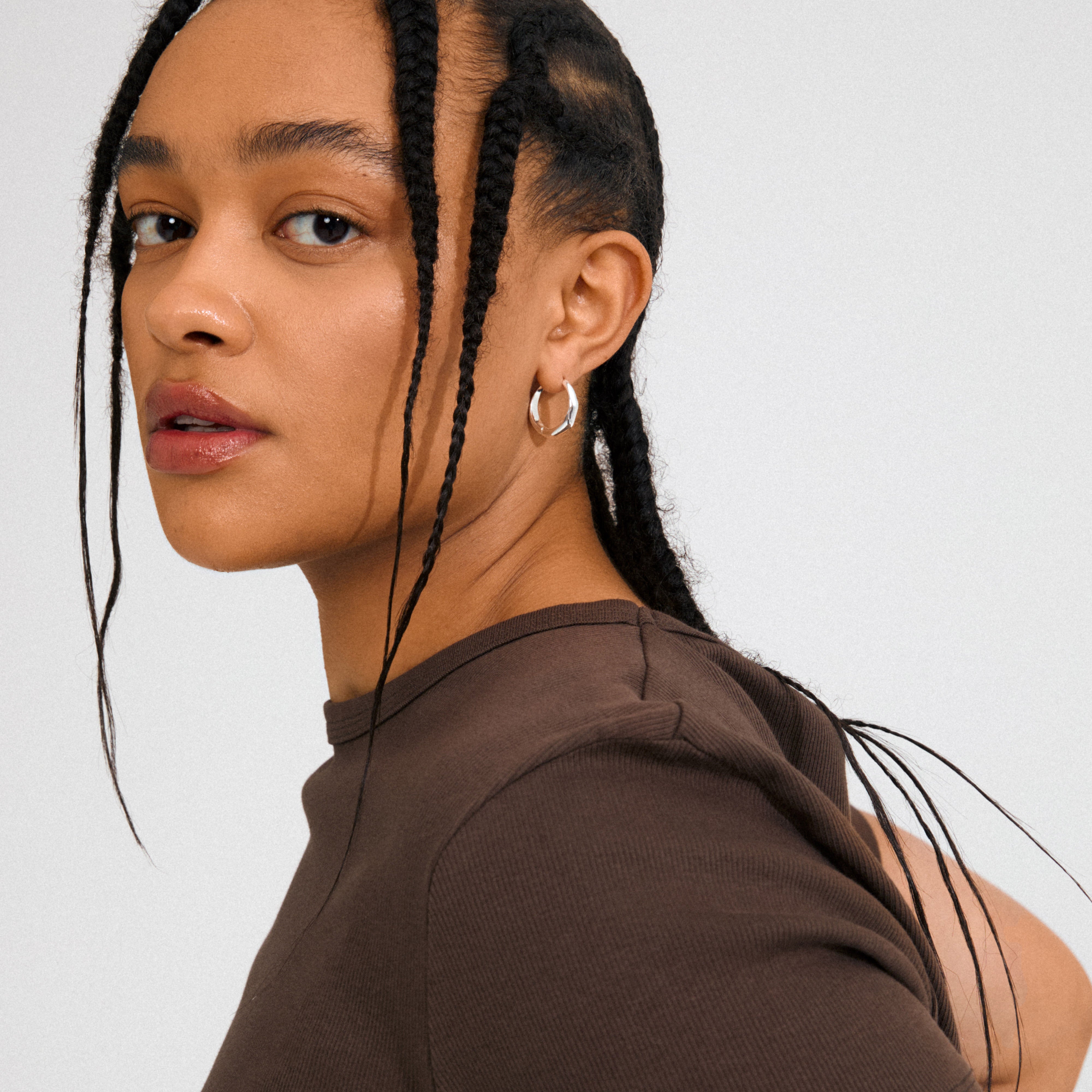 Silver-plated HARRISON hoops by Pilgrim, featuring wavy shapes and click clasps for stylish, effortless wear. Made from 99% recycled material.