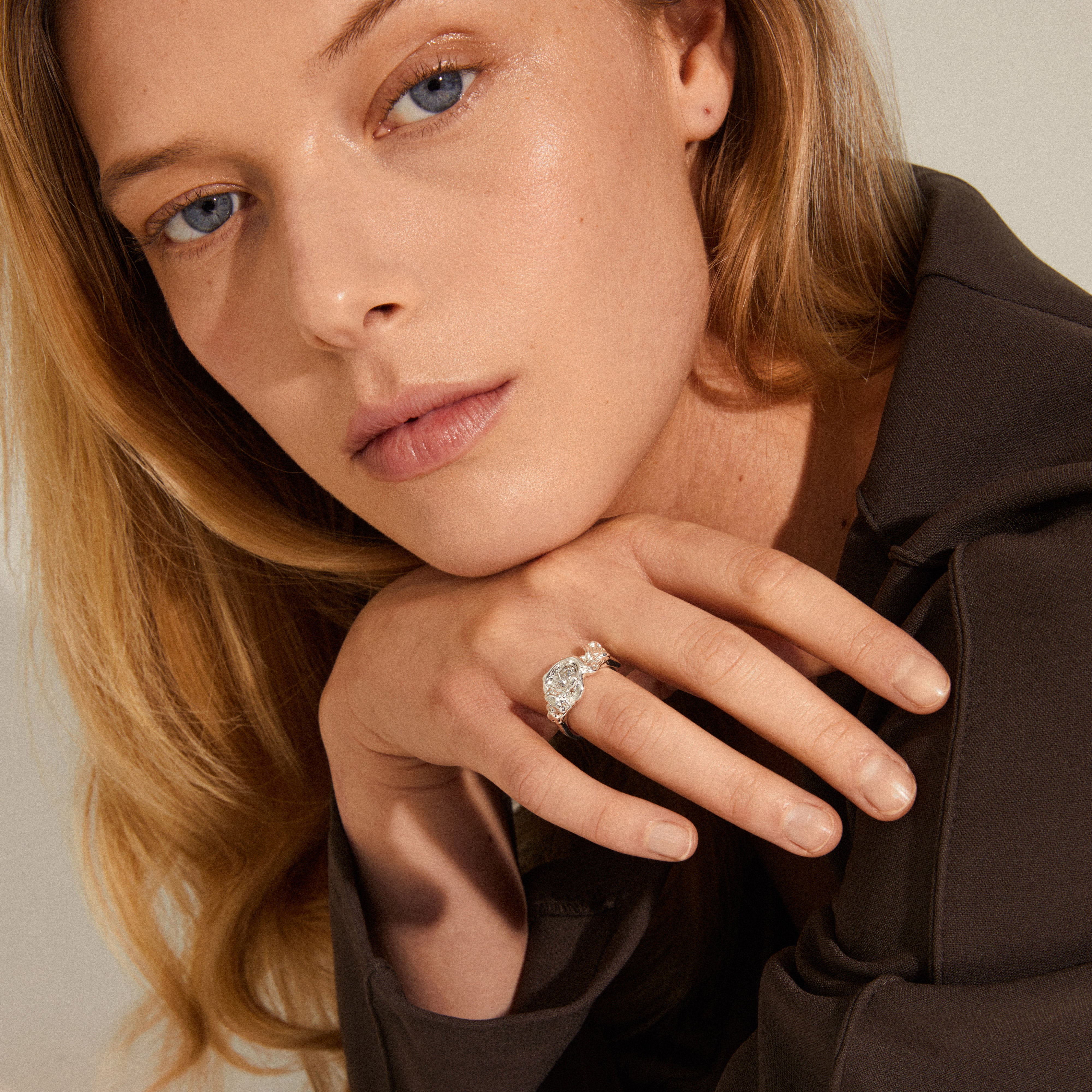 Close-up of a woman showcasing the TINA organic shape crystal ring, silver-plated with an organic, handcrafted design, featuring a Preciosa crystal.