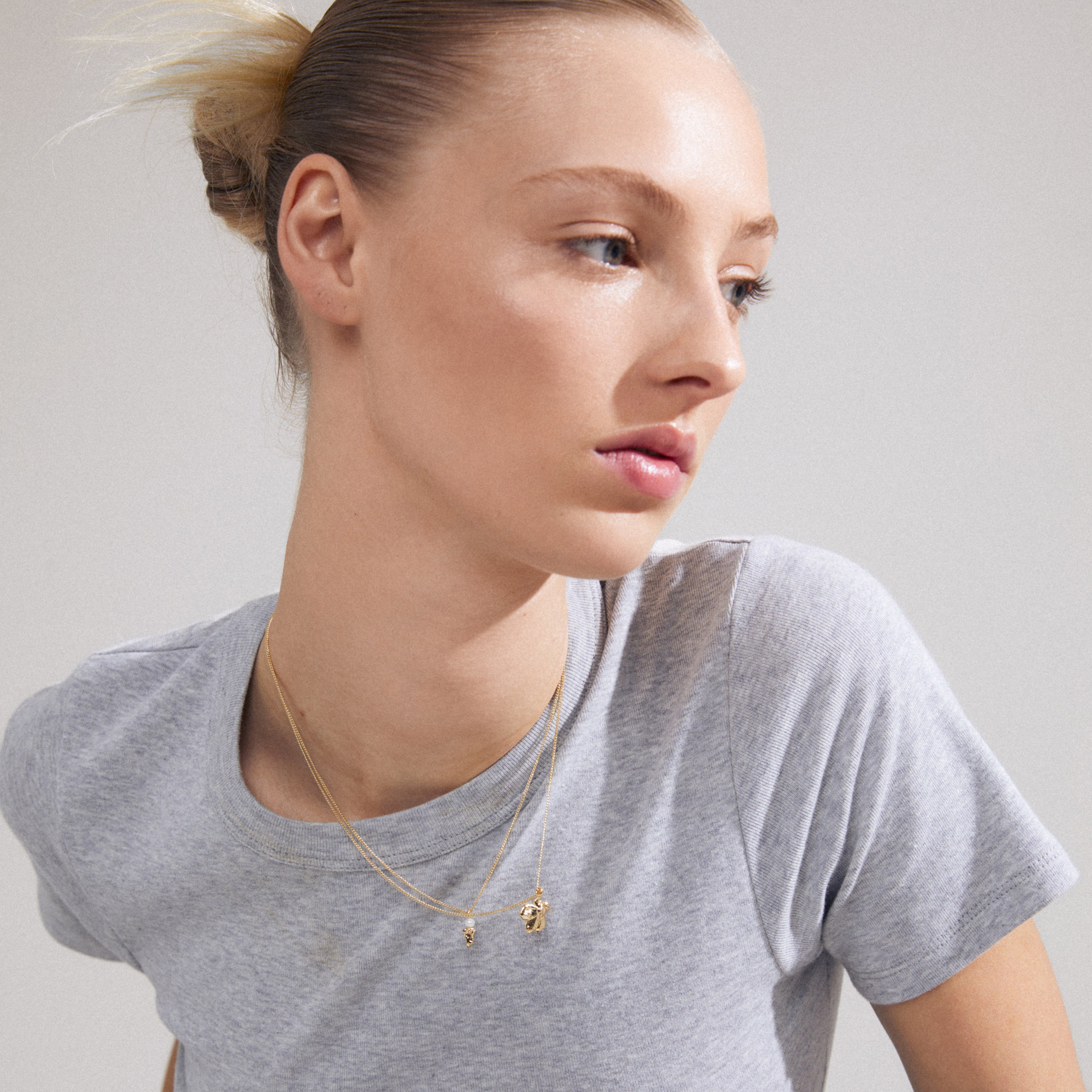 ZHURI necklace 2-in-1 set gold-plated on a woman, featuring floral and pearl elements for a chic, layered look.