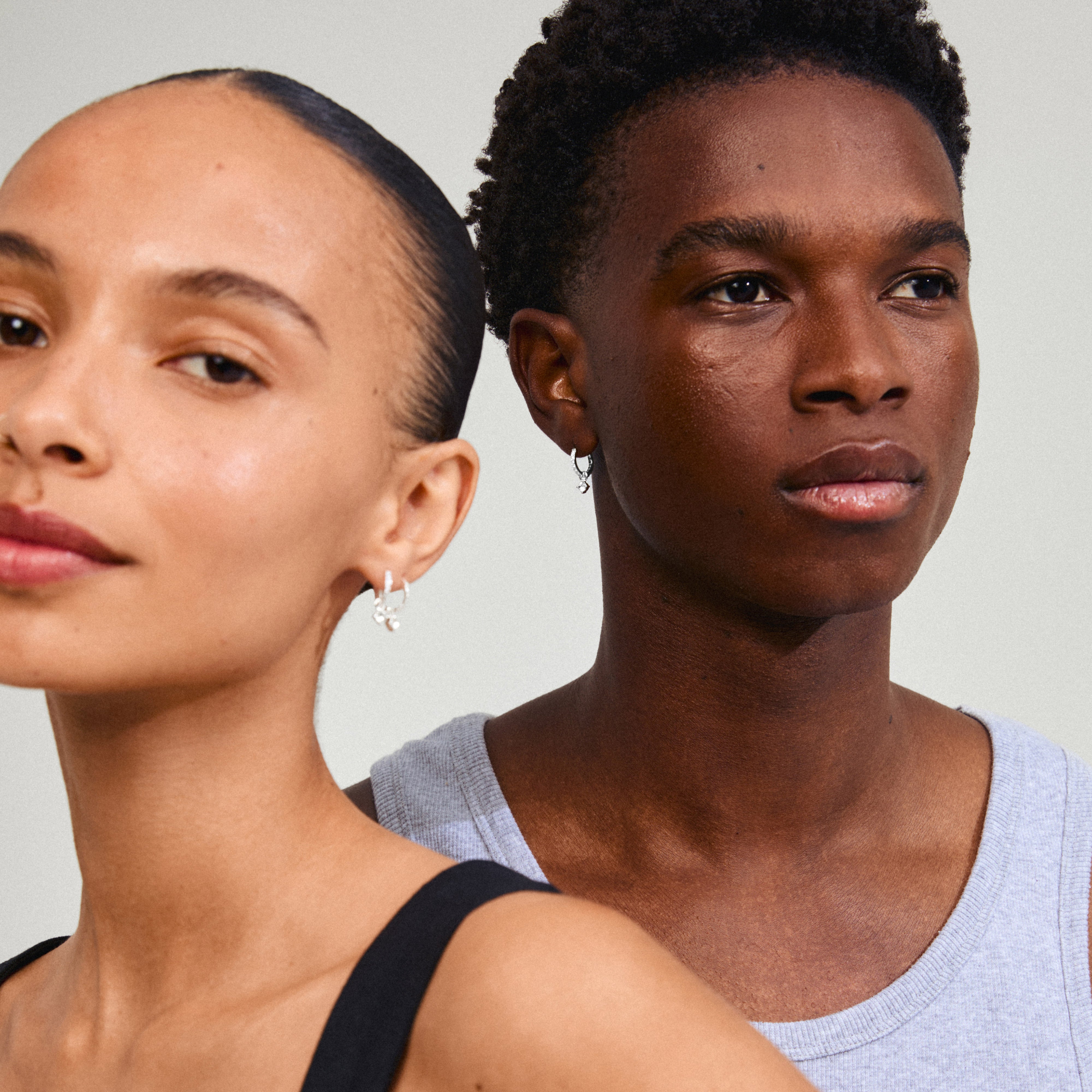 JOA crystal hoop earrings, silver-plated, featuring a loose crystal pendant for a touch of sparkle, worn by a woman with a ponytail.