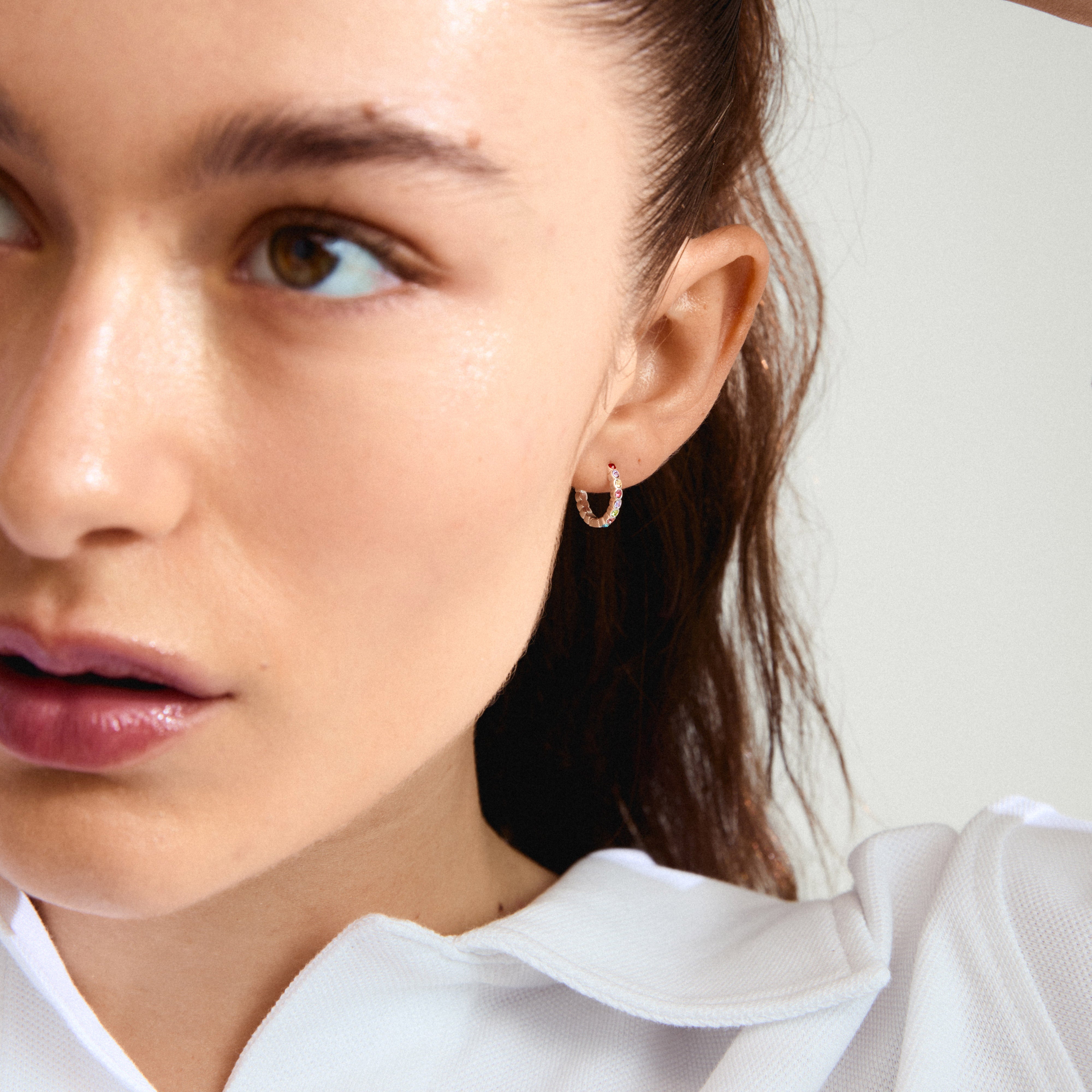 KLEOPRATRA hoop earrings silver-plated, adorned with colourful Preciosa crystals, displayed on a woman wearing a white shirt, highlighting their sparkle and elegance.