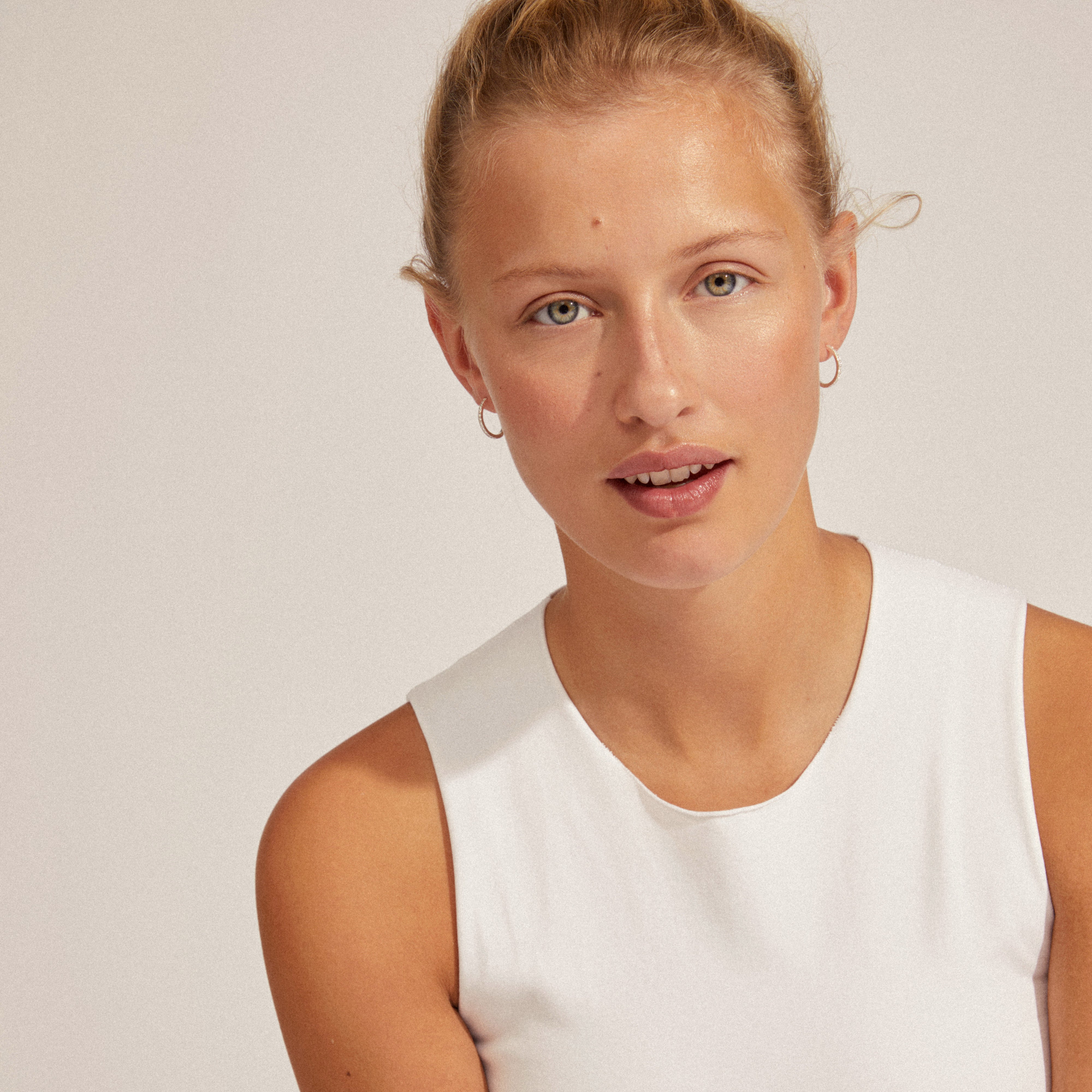 EBNA medium crystal hoops silver-plated, worn by a woman in a white shirt, showcasing their elegant shine and stylish click-lock design.