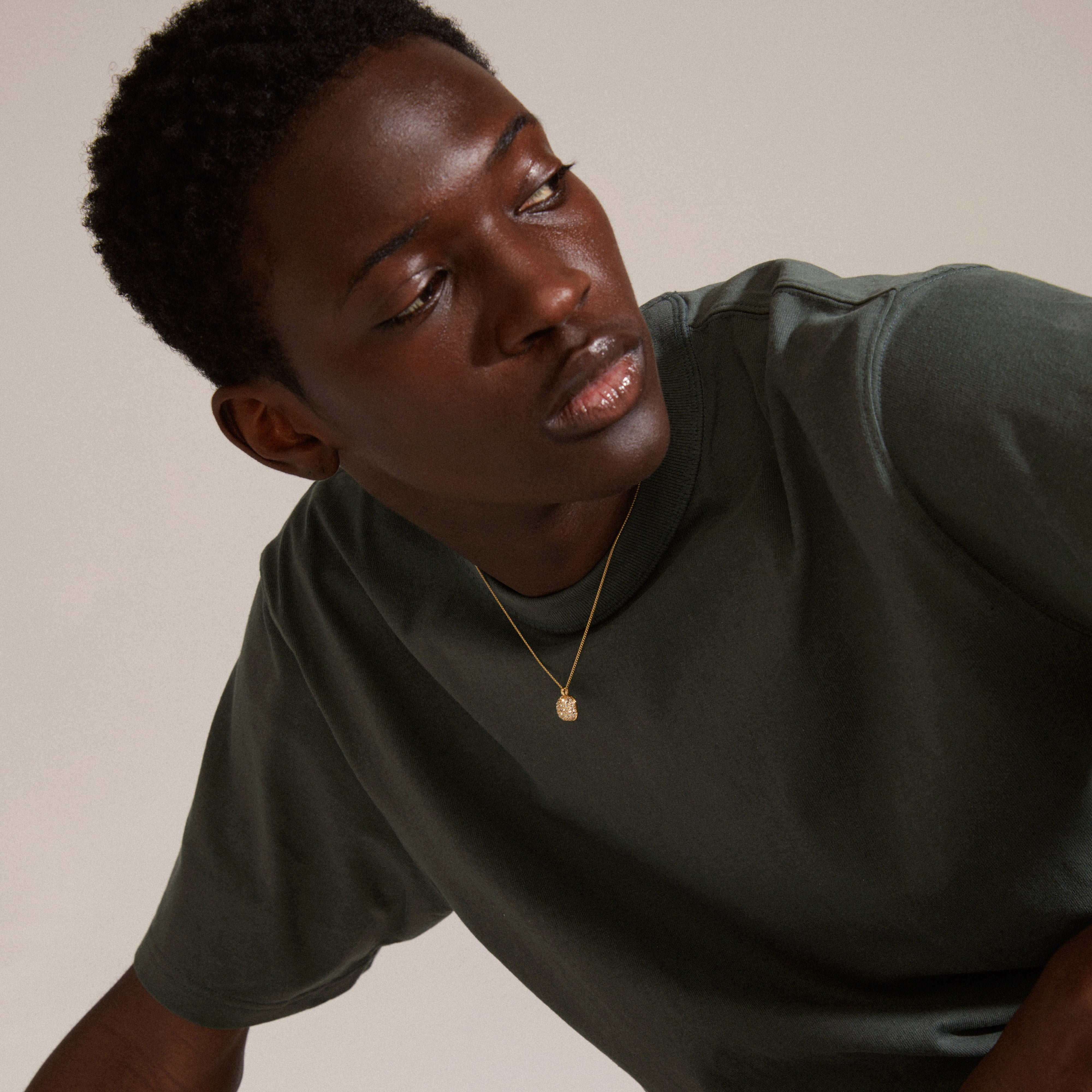CINDY crystal pendant necklace, gold-plated, featuring a slim chain and sparkling crystals, worn by a man in a green shirt. Perfect for stylish layering.
