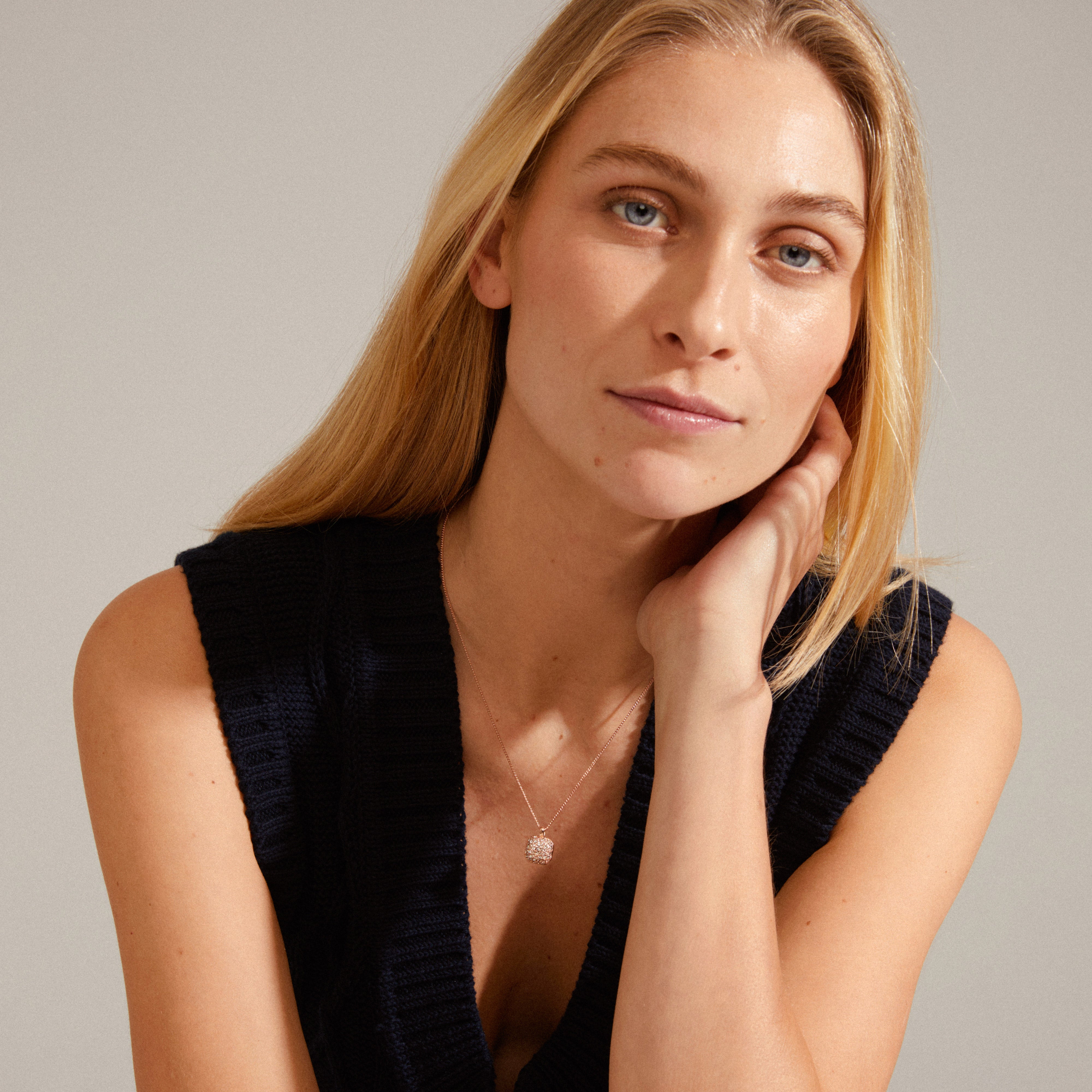 CINDY crystal pendant necklace rosegold-plated, featuring a slim chain and square-shaped pendant with glittering Preciosa crystals, worn by a woman with blonde hair.
