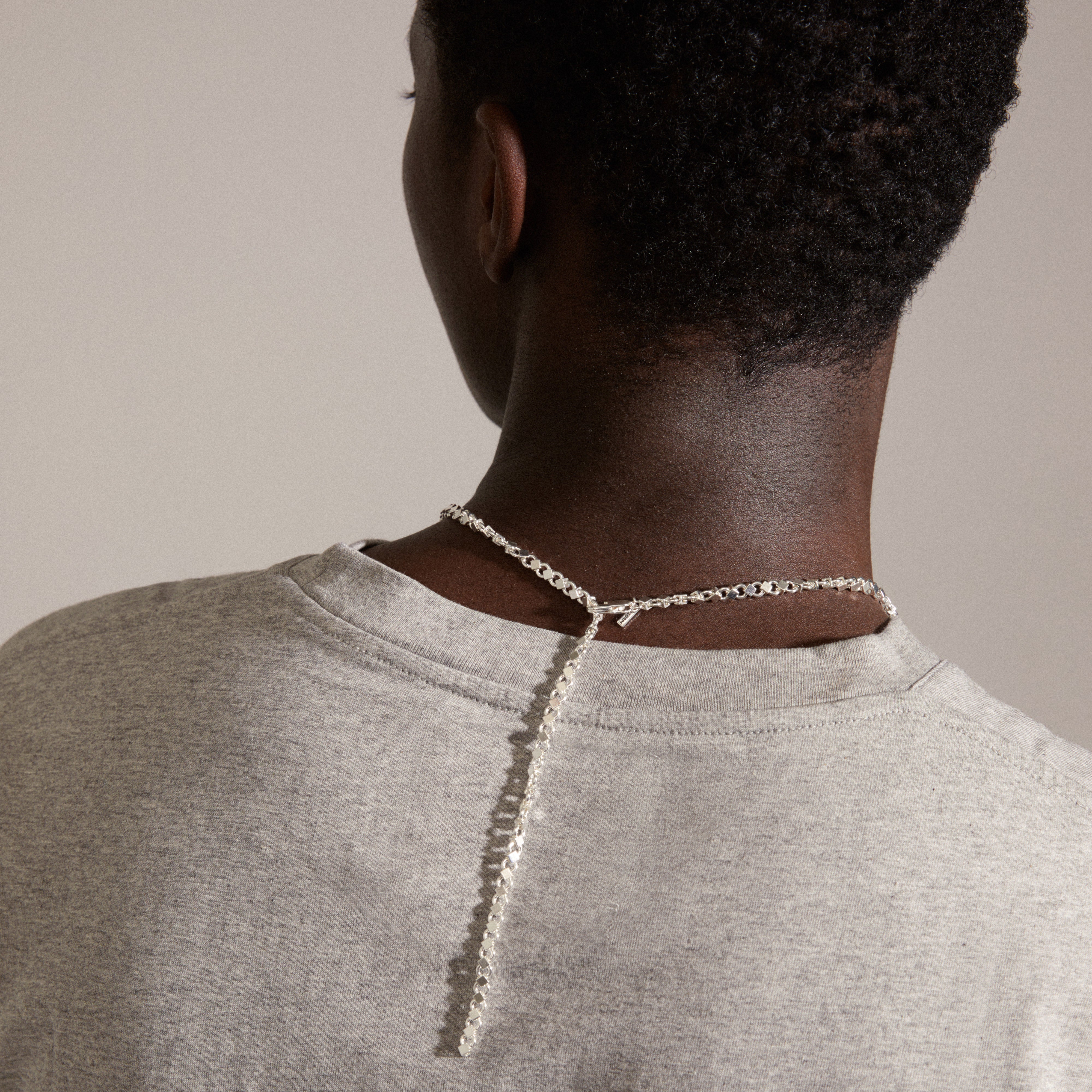 DESIREE necklace silver-plated, featuring a unique chain design with cubes and round links, worn by a woman, showcasing its elegant style and craftsmanship.