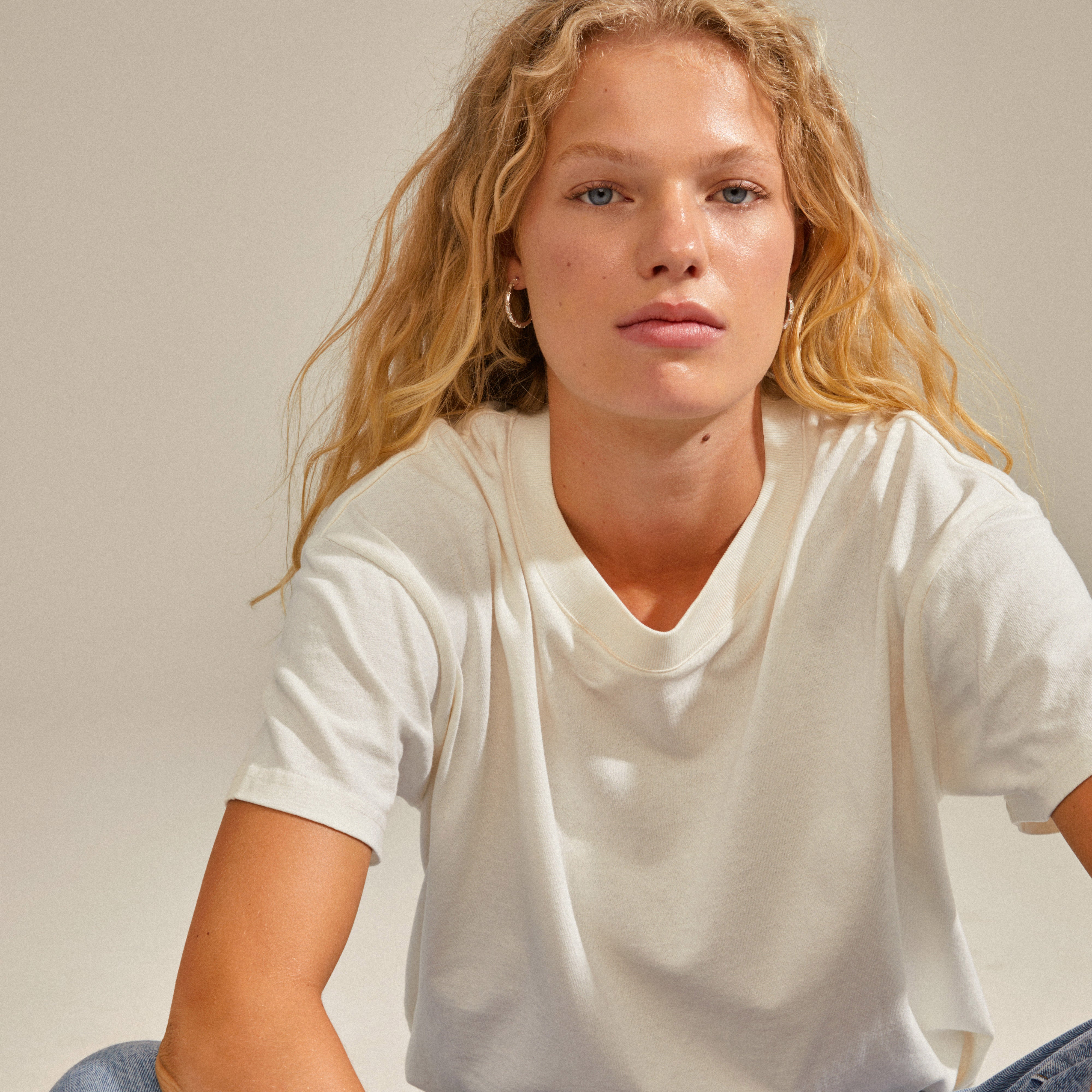 Young woman wearing RUE hoops silver-plated earrings with sparkling glass stones, showcasing Pilgrim's blend of timeless and trendy Scandinavian jewelry.