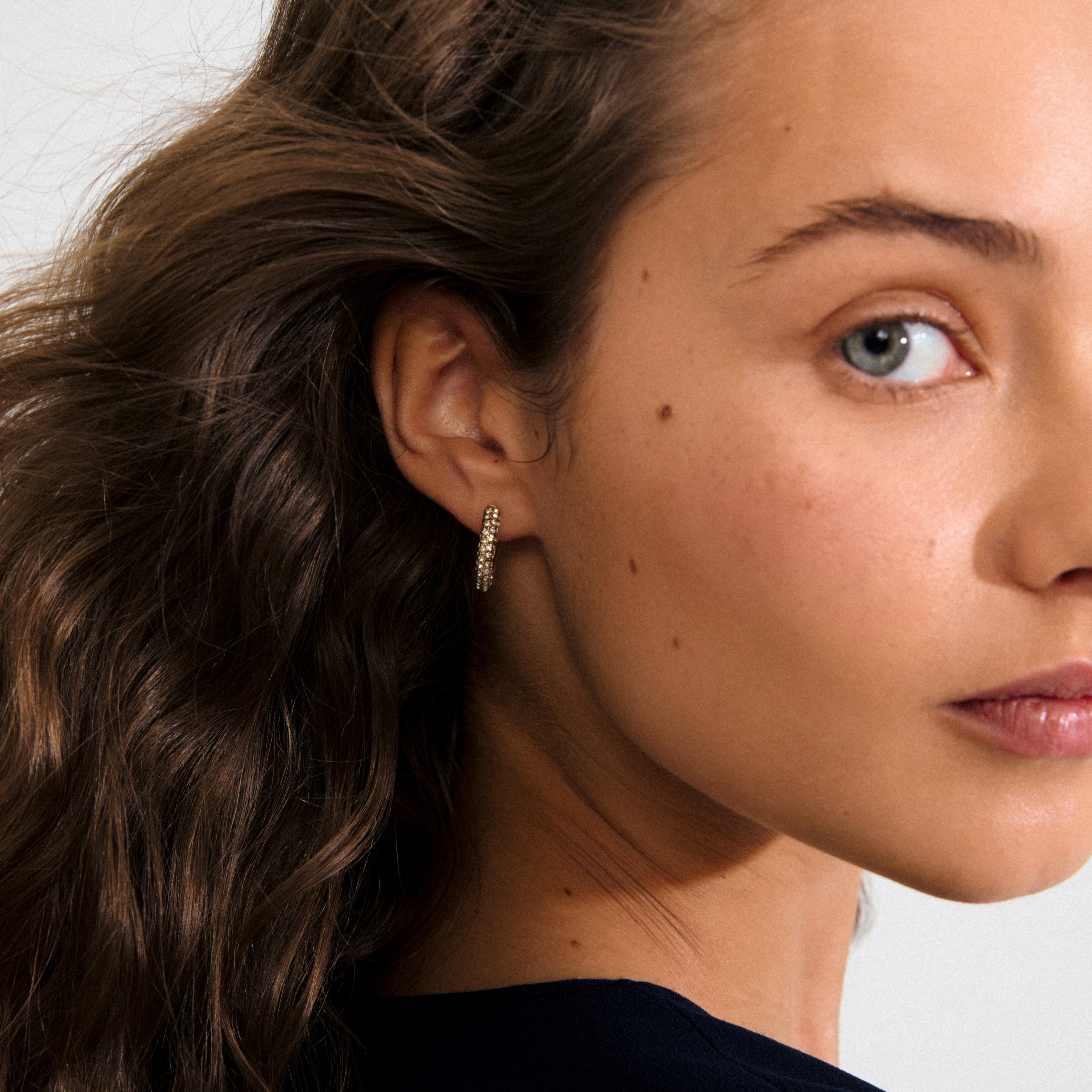 Gold-plated TATUM medium hoops adorned with Preciosa crystals, featuring snap locks for comfort and style; crafted from 97% recycled materials for eco-conscious fashion.