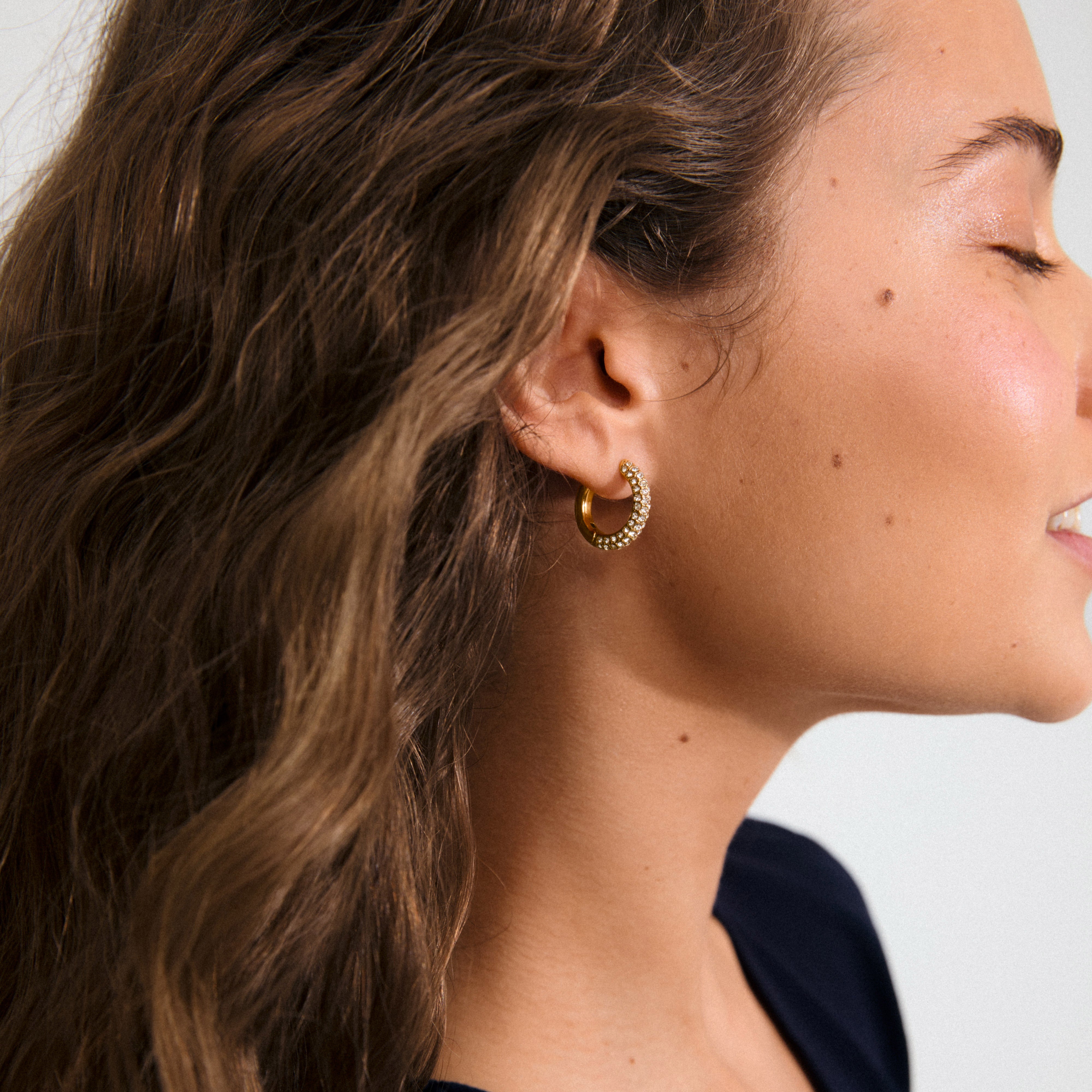 TATUM medium hoops, gold-plated, feature sparkling Preciosa crystals and snap locks for easy styling. Made from 97% recycled materials, perfect for day-to-night elegance.