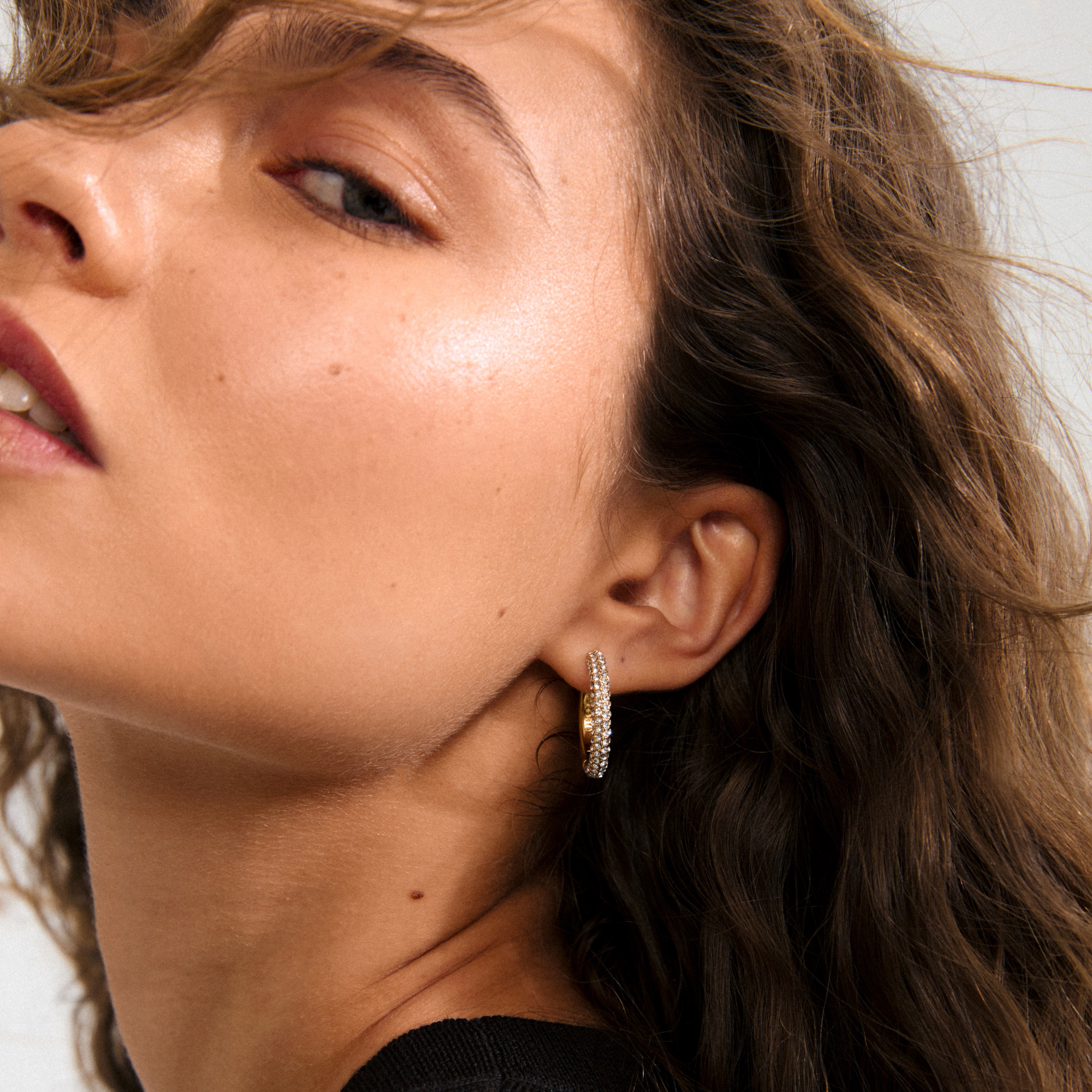 TATUM large hoops gold-plated, adorned with Preciosa crystals, offer a chic, sustainable touch for versatile day-to-night style with easy snap locks.